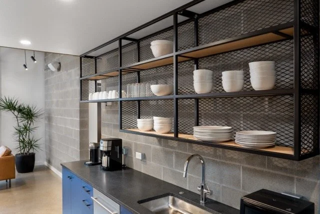 Custom open industrial shelving in front of a CMU block wall inside a creative tech firm office in Hillsboro, Oregon