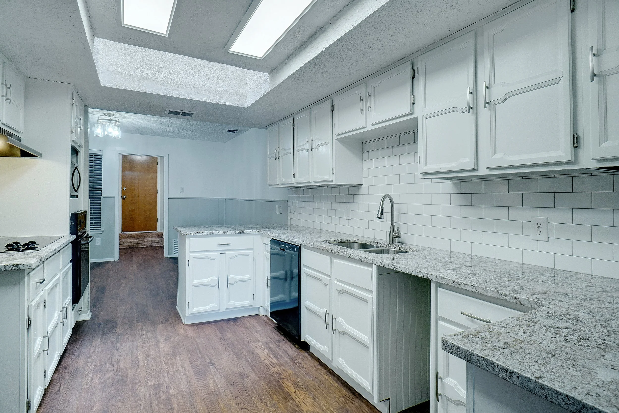 Kitchen with granite countertops and skylight