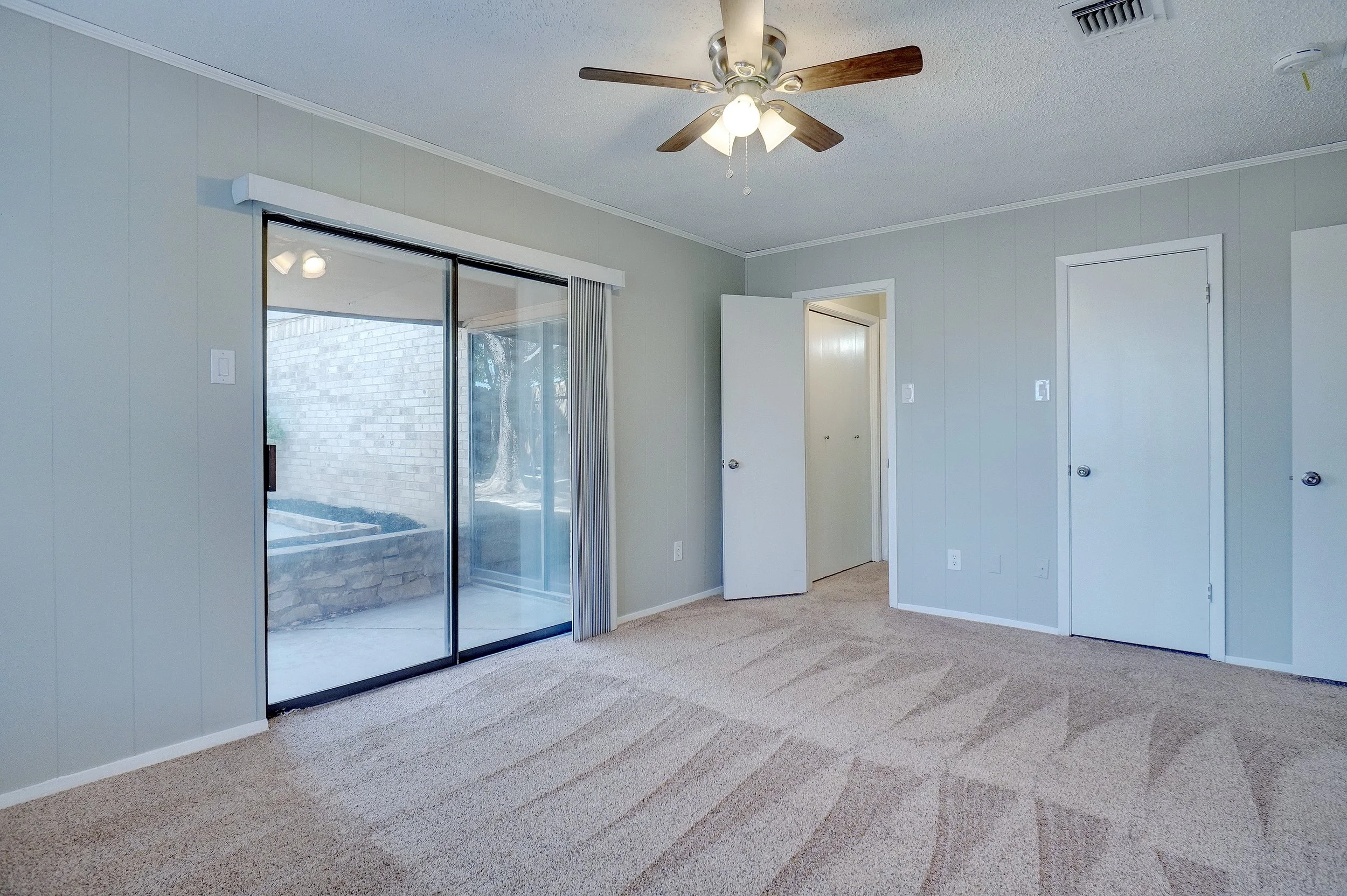 Third bedroom with patio access and walk-in closet.
