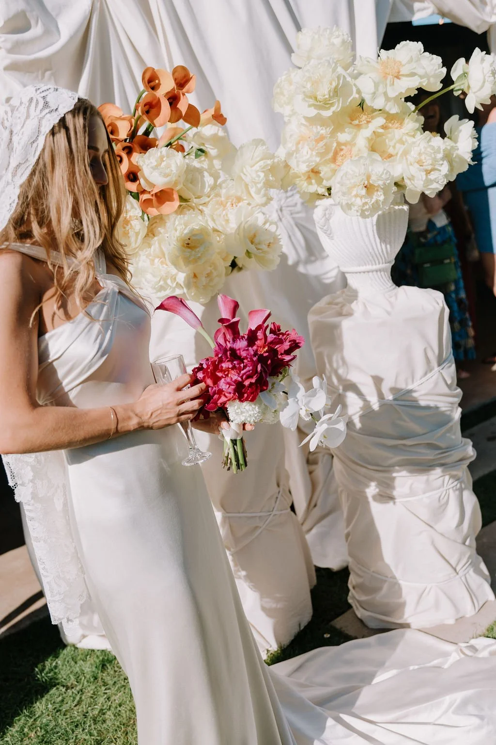 European inspired bridal look, modern, cool bride Emily holding a colourful wedding bouquet beside floral ceremony styling