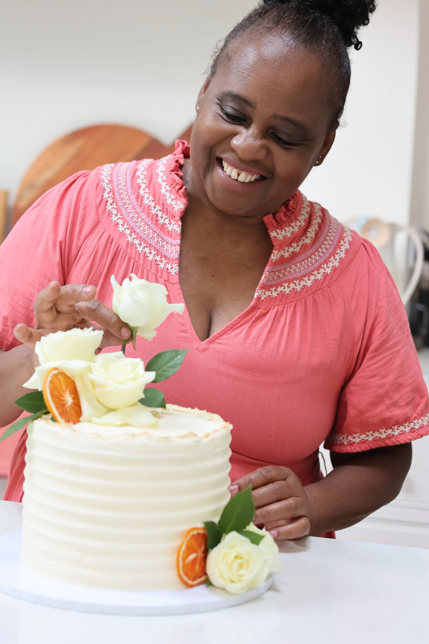 Lois, the baker and designer behind My Heavenly Cakes Cambridge, decorating a buttercream wedding cake