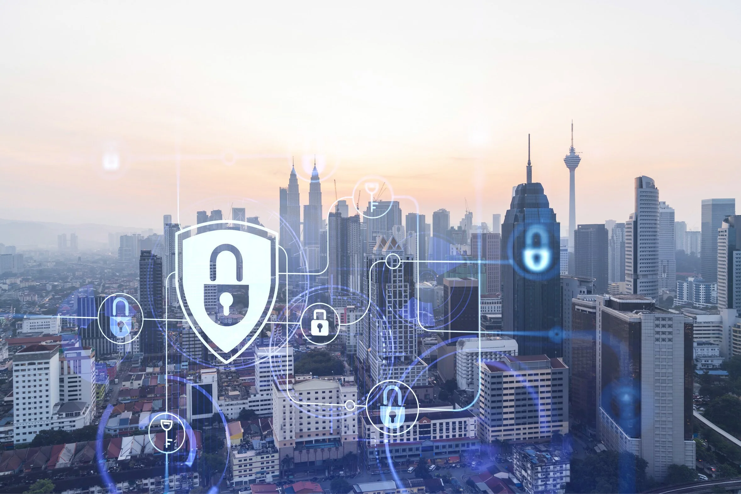 Aerial cityscape at sunset with digital security shield and padlock icons overlaid, representing networked security infrastructure