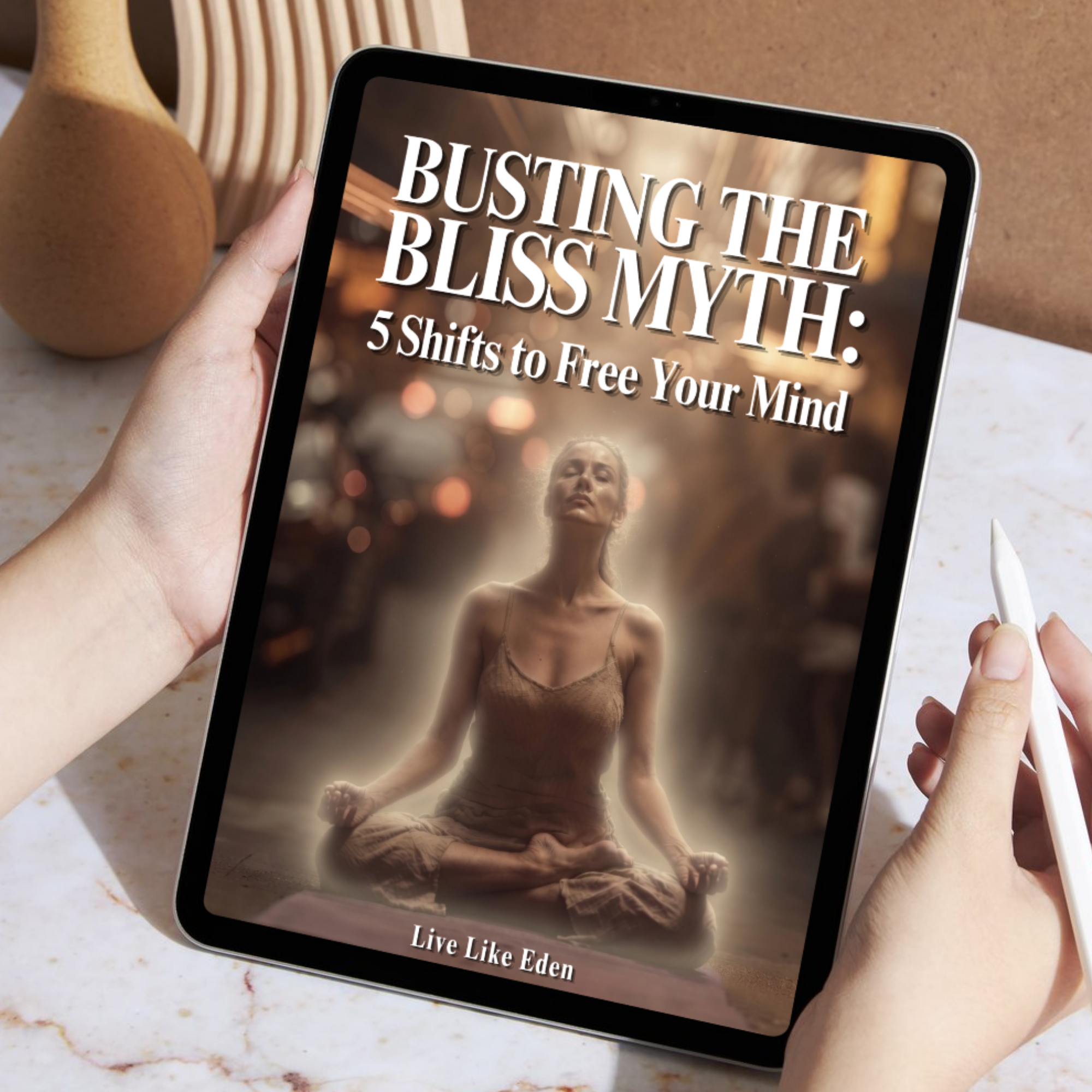 A person holding a tablet displaying a book cover titled "Busting the Bliss Myth: 5 Shifts to Free Your Mind" with a blurred background of a woman in a neutral top, possibly in an indoor setting.