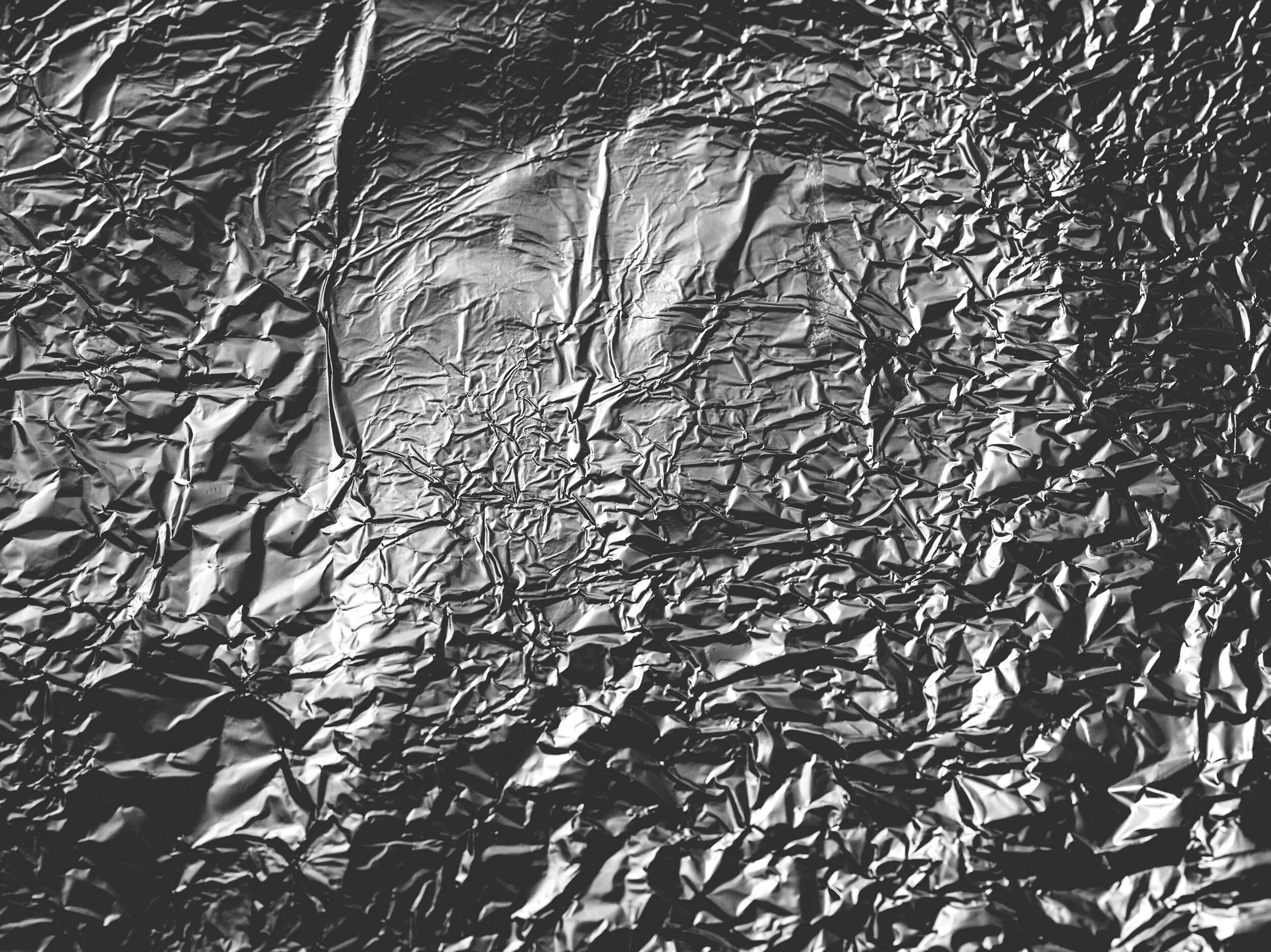 A crumpled piece of aluminum foil with shiny, wrinkled texture.