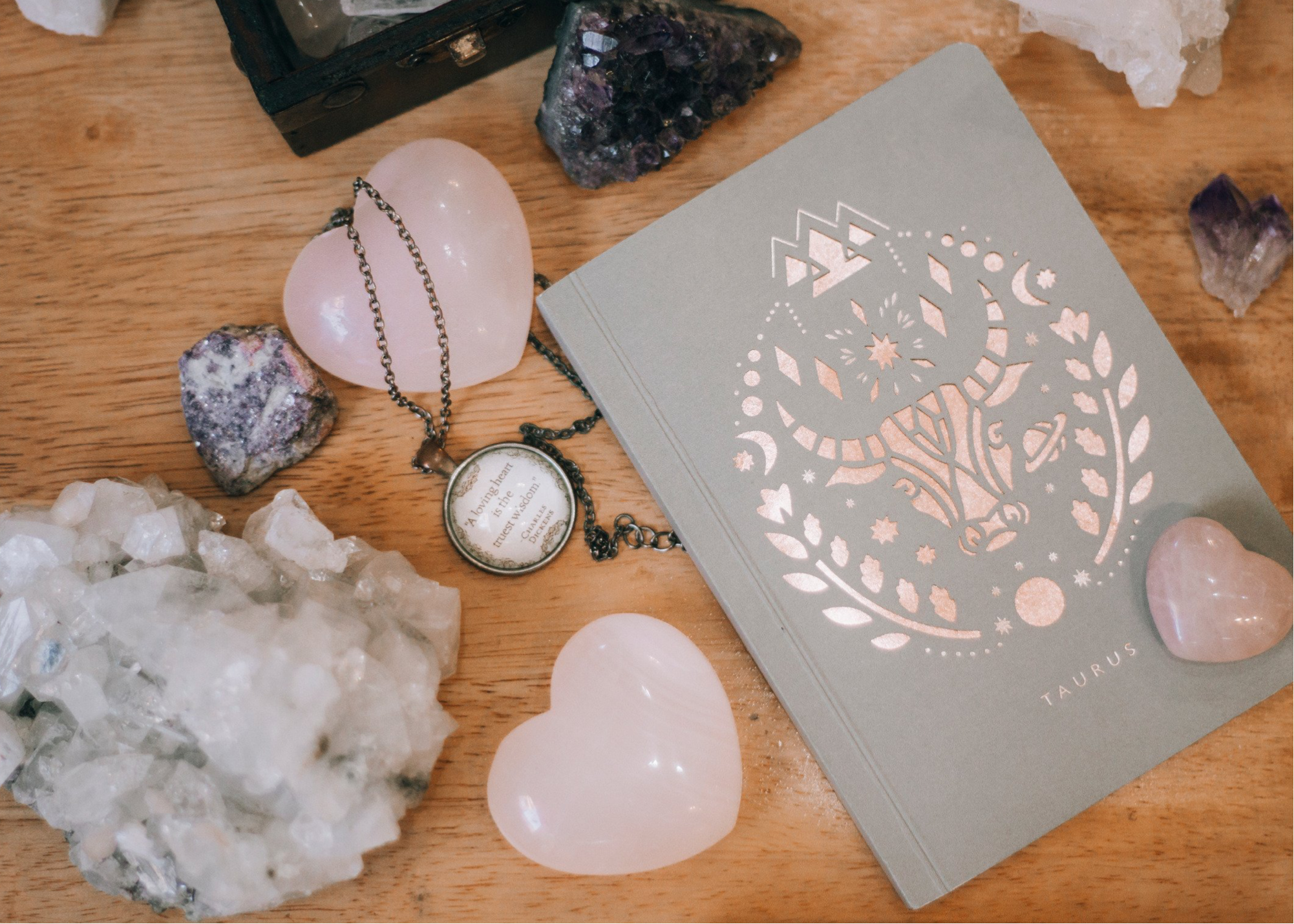 Rose quartz heart crsytals clear quartz cluster and taurus card on wooden table
