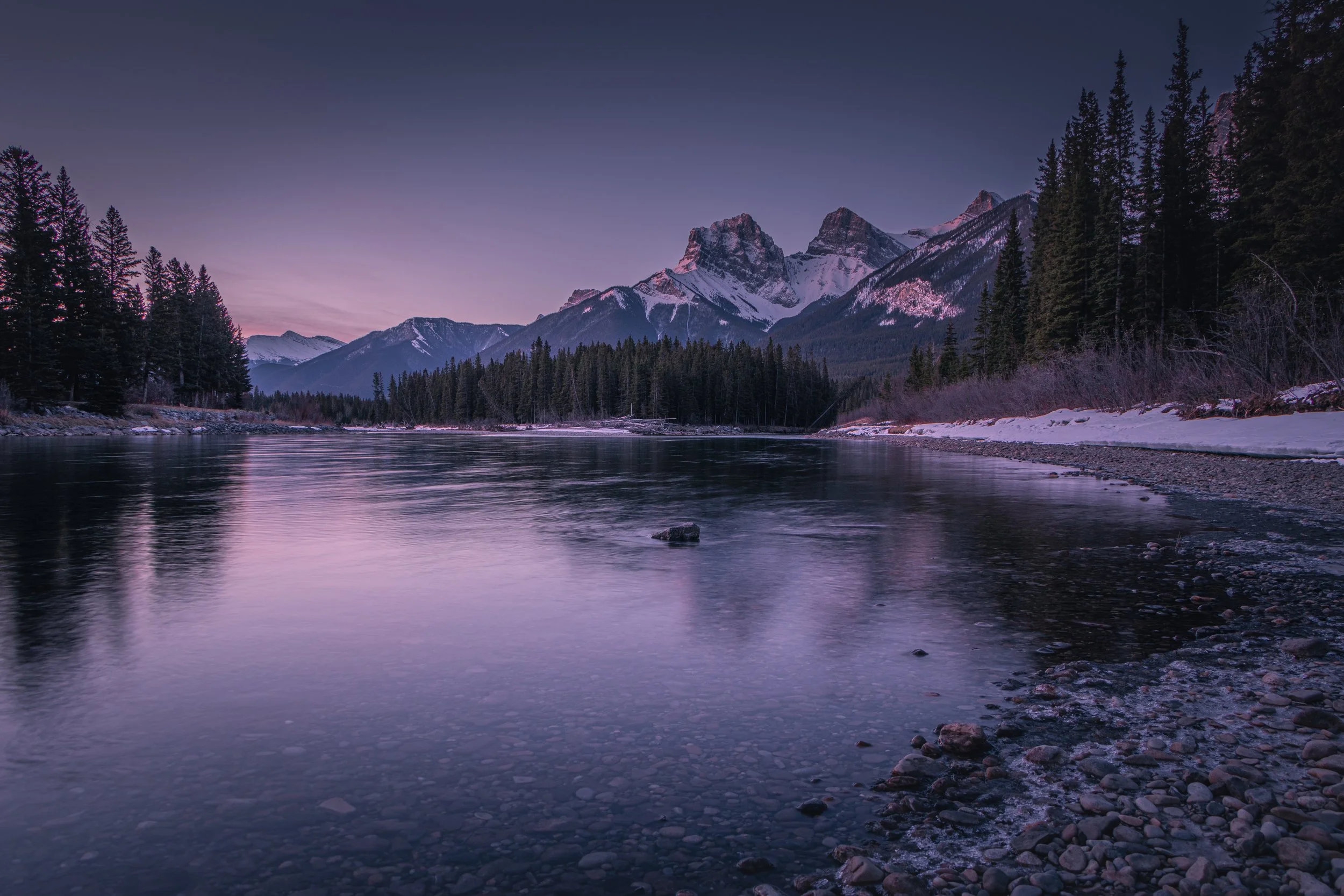 WHISPERS OF THE BOW.

This image captures one of the most iconic views in the Canadian Rockies: The Three Sisters in Canmore, Alberta. Set against the tranquil waters of the Bow River during the "blue hour," the photograph highlights the rugged majes