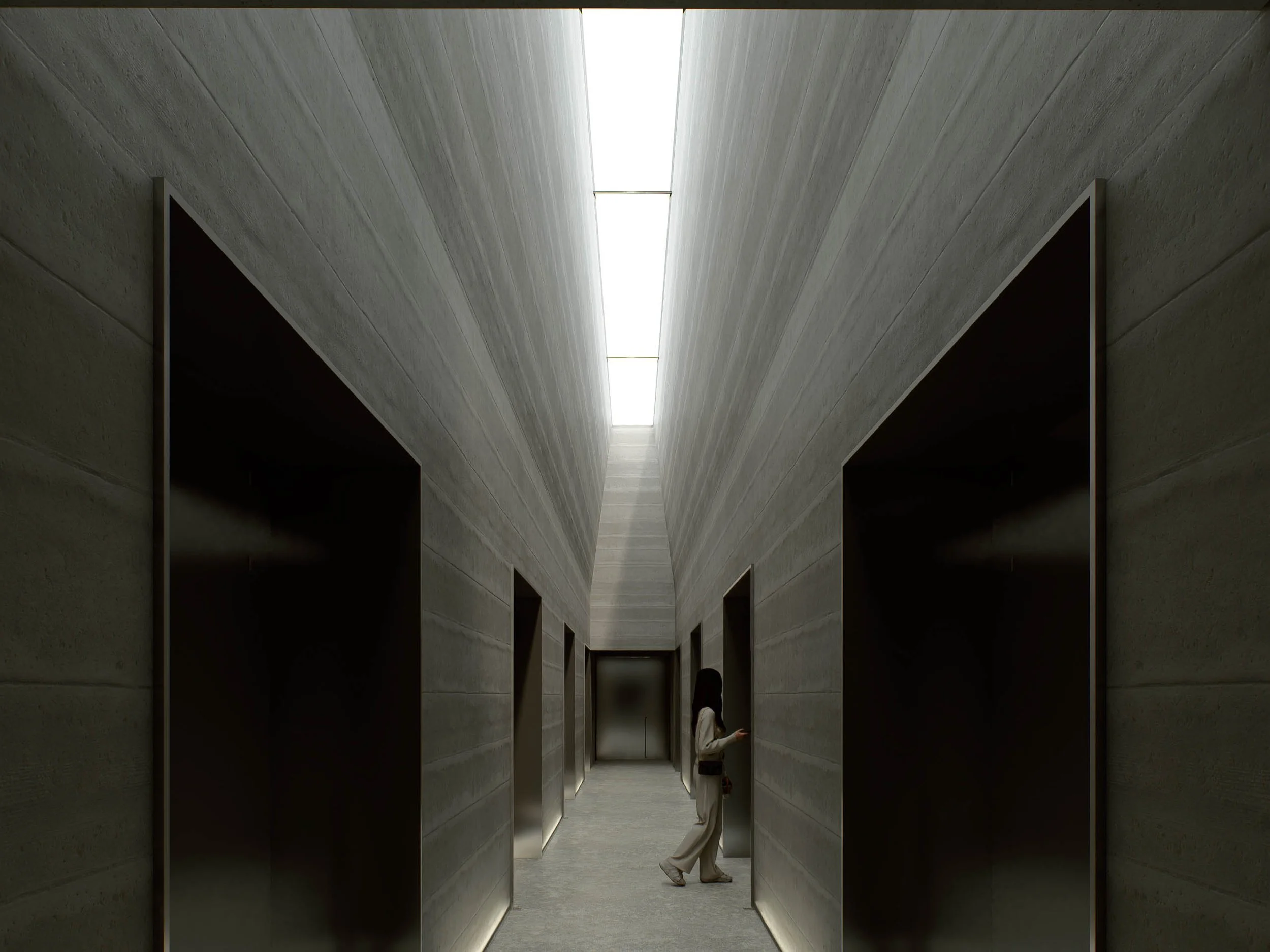 A modern minimalist hallway with high ceiling and natural light from skylight, concrete walls and dark openings on both sides, with a woman in beige pants and white shirt walking along the corridor.