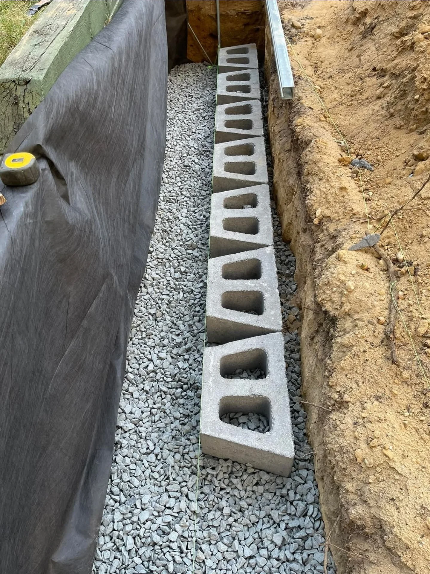 Retaining wall and drainage installation by The Lazy Lawn, professional landscaping services in Davis County, Utah.
