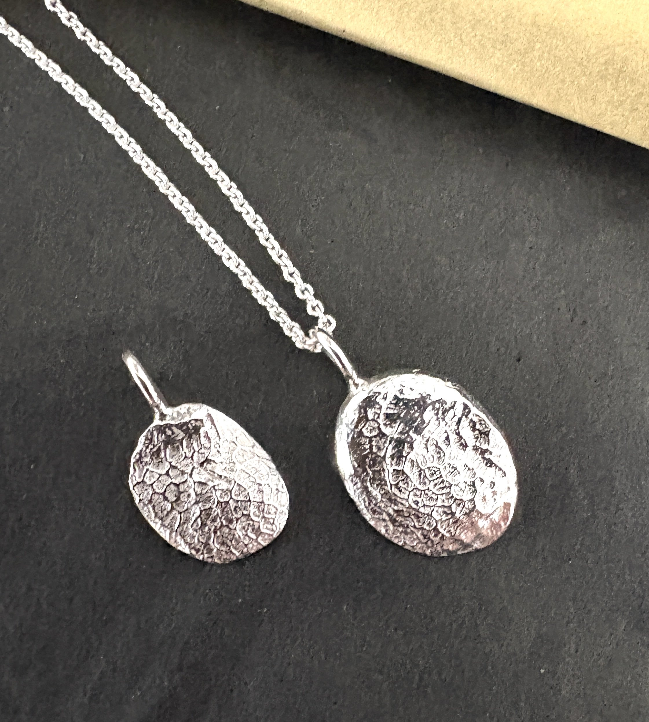 12. Aftryk af hundesnude i sølv . Stor 1,5 cm.x 1,2 cm.  uden kæde. Pris 1000,-
Lille 1,5cm. x1,0cm. uden ophæng. Pris 900,-,- kæde 235,-
Forgyldt plus 200,-