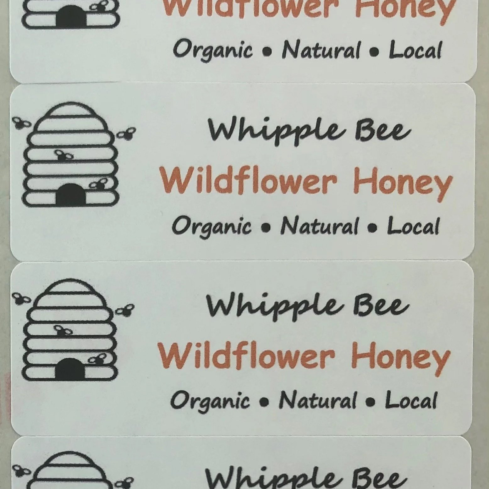 Whipple Bee Wildflower Honey labels reading “Organic, Natural, Local,” honoring the family’s roots in sustainable beekeeping and handmade goods.