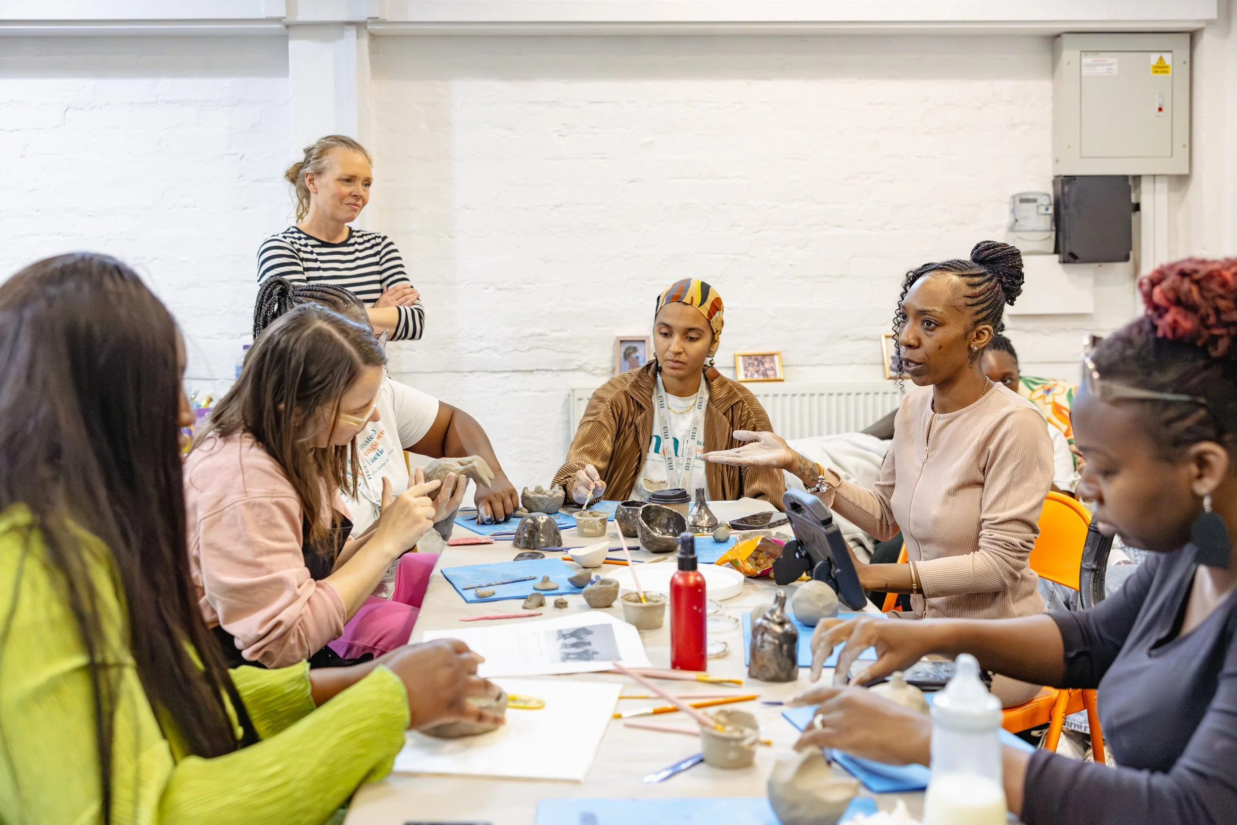 A group of women making objects out of clay.
