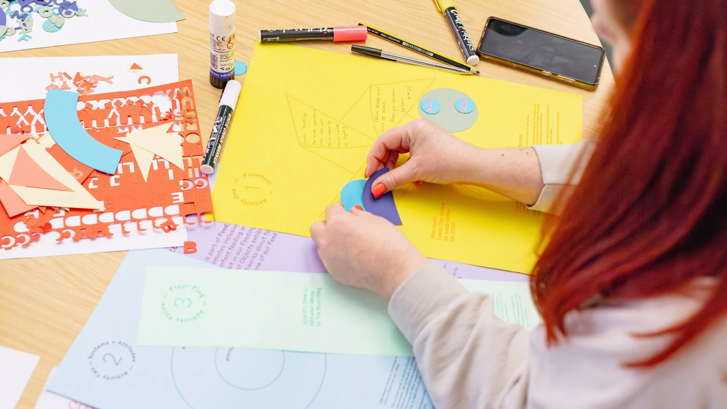A woman's hands holding two pieces of coloured card.