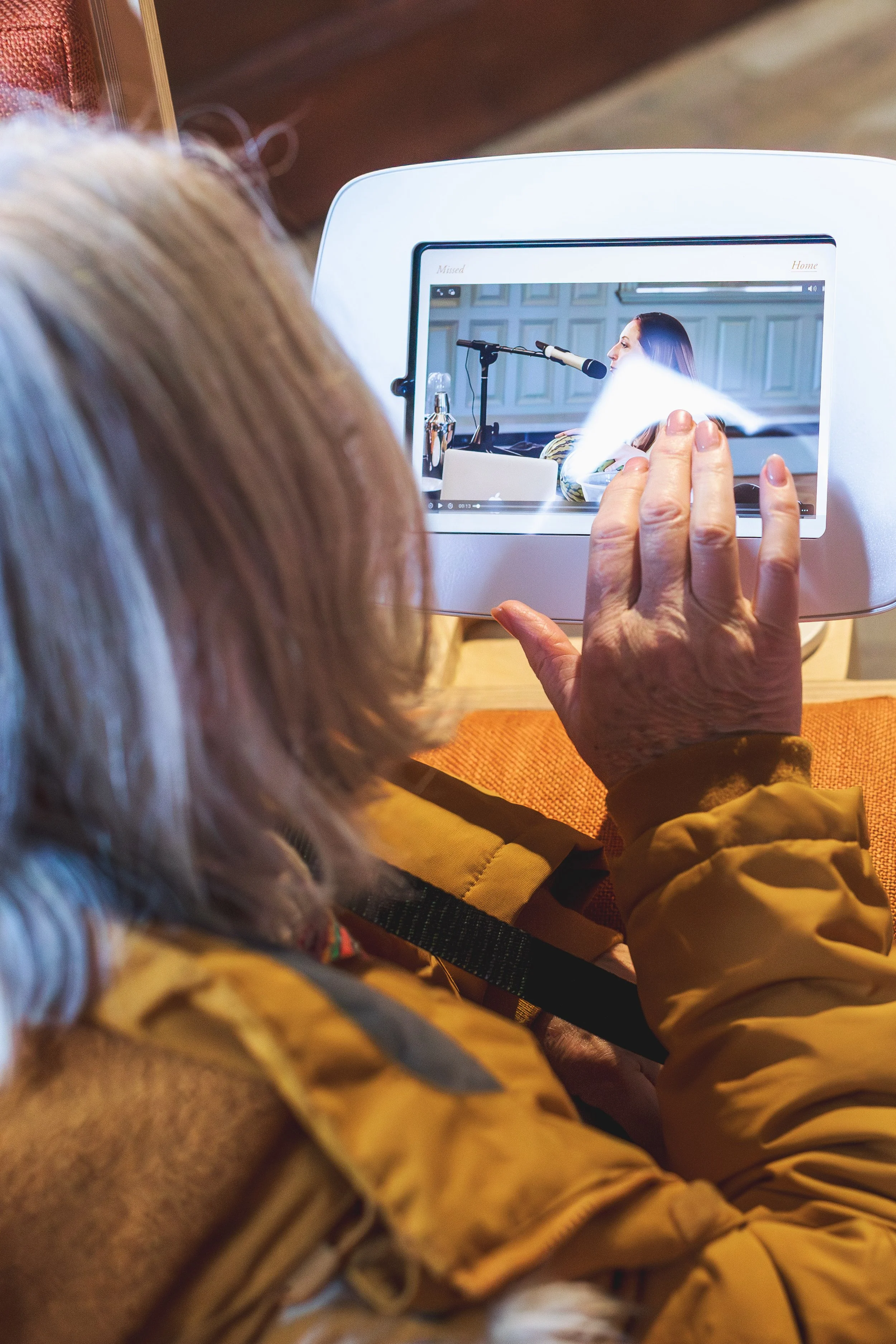 Person's hand pressing an iPad screen.