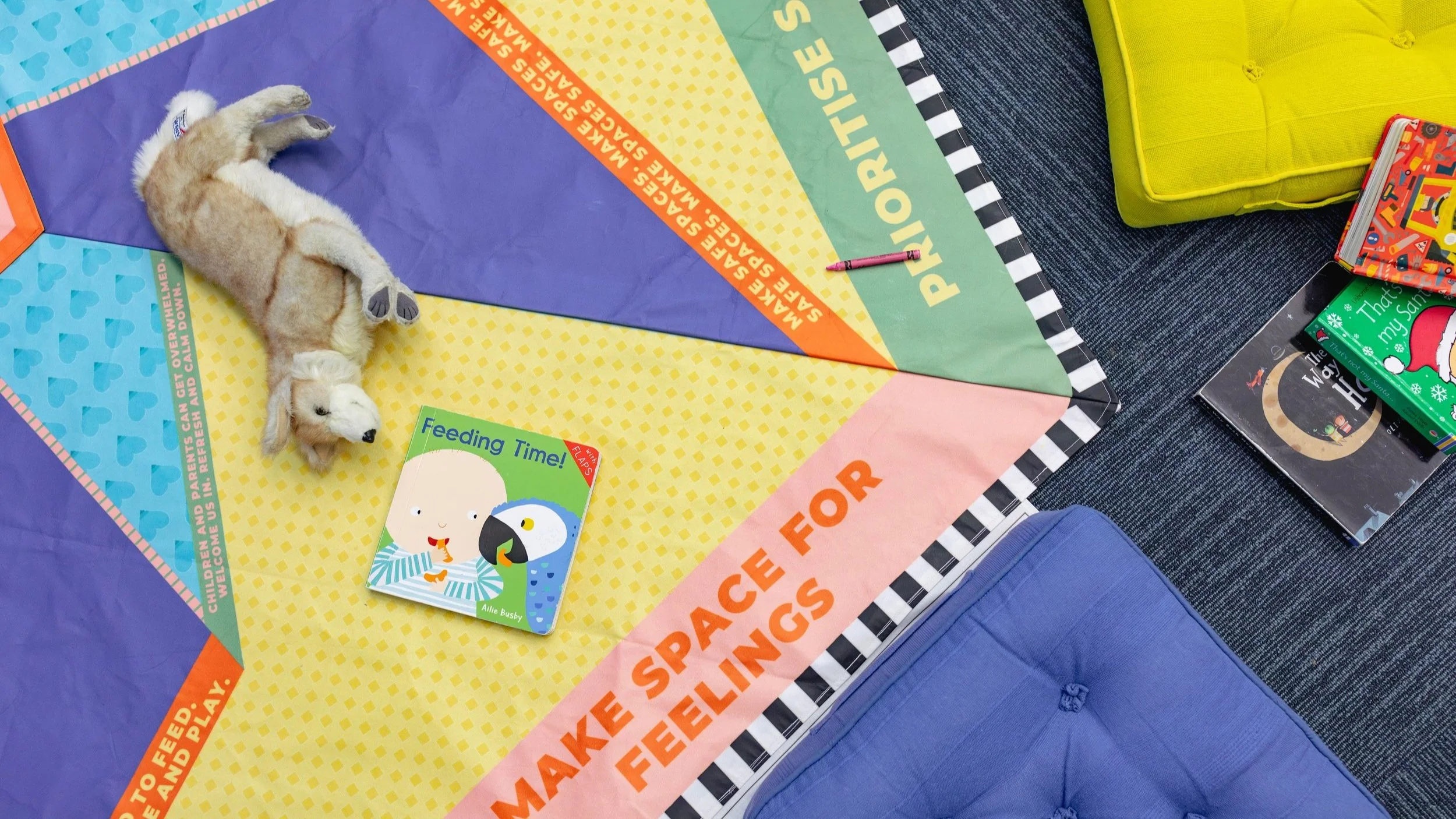 The edge of a colourful mat with the words 'Make Spaces for Feelings' on it.