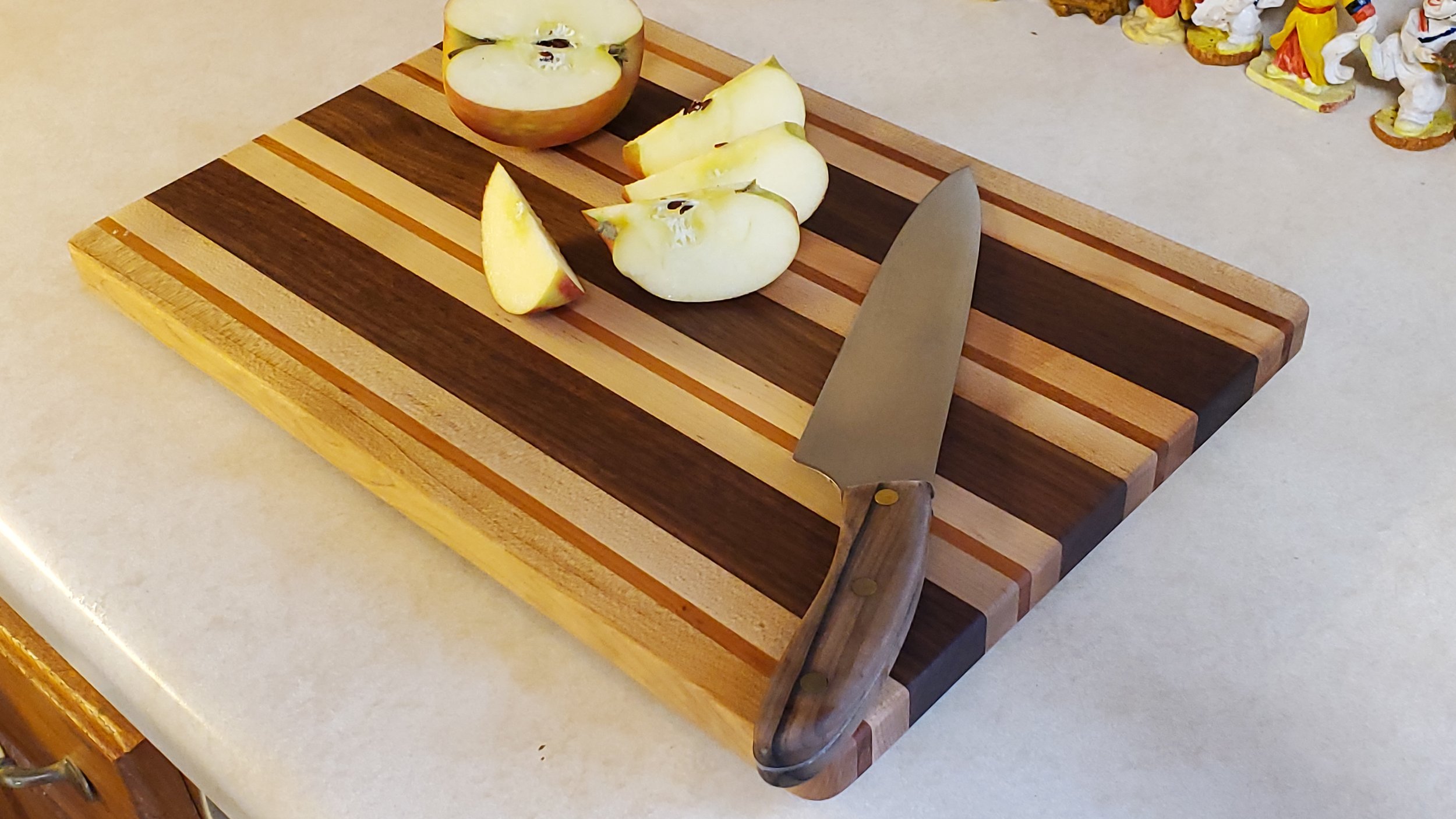 Shown is  a Three-Color Full-size cutting board.  
Full Sized Cutting Boards are 11.5 inch wide by 17 inch long.
Each Board is Hand-crafted with care from Beautiful hardwoods such as Walnut, Cherry and Maple. 
Custom art work is included Free.
