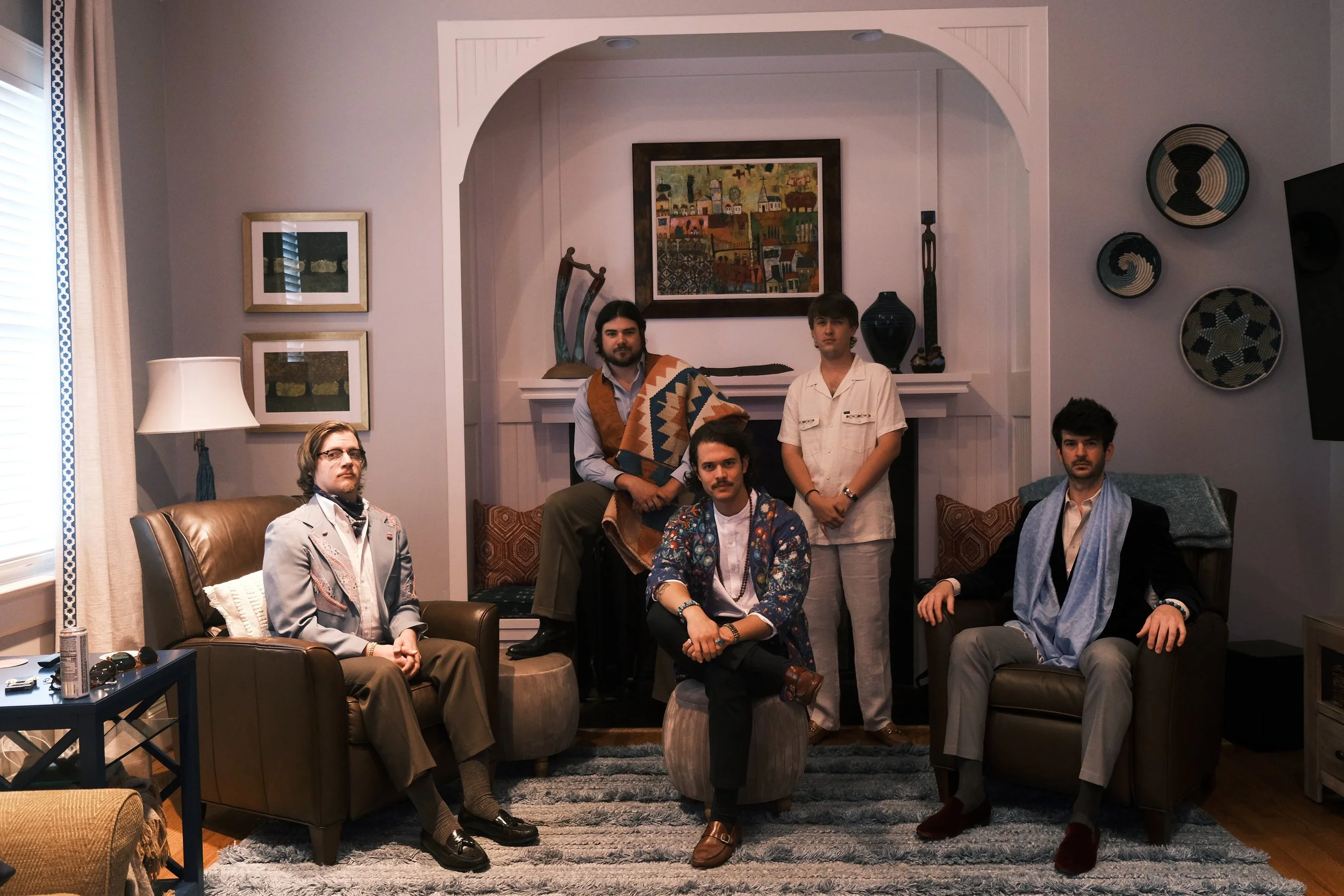 Joe May's Month of Mondays dressed in vintage-inspired clothing pose in a stylish living room with art and decor.