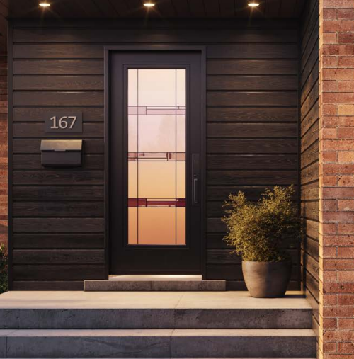 Front door of a house with black siding, brick wall on the right, house number 167, a mailbox, and a potted plant on the step.