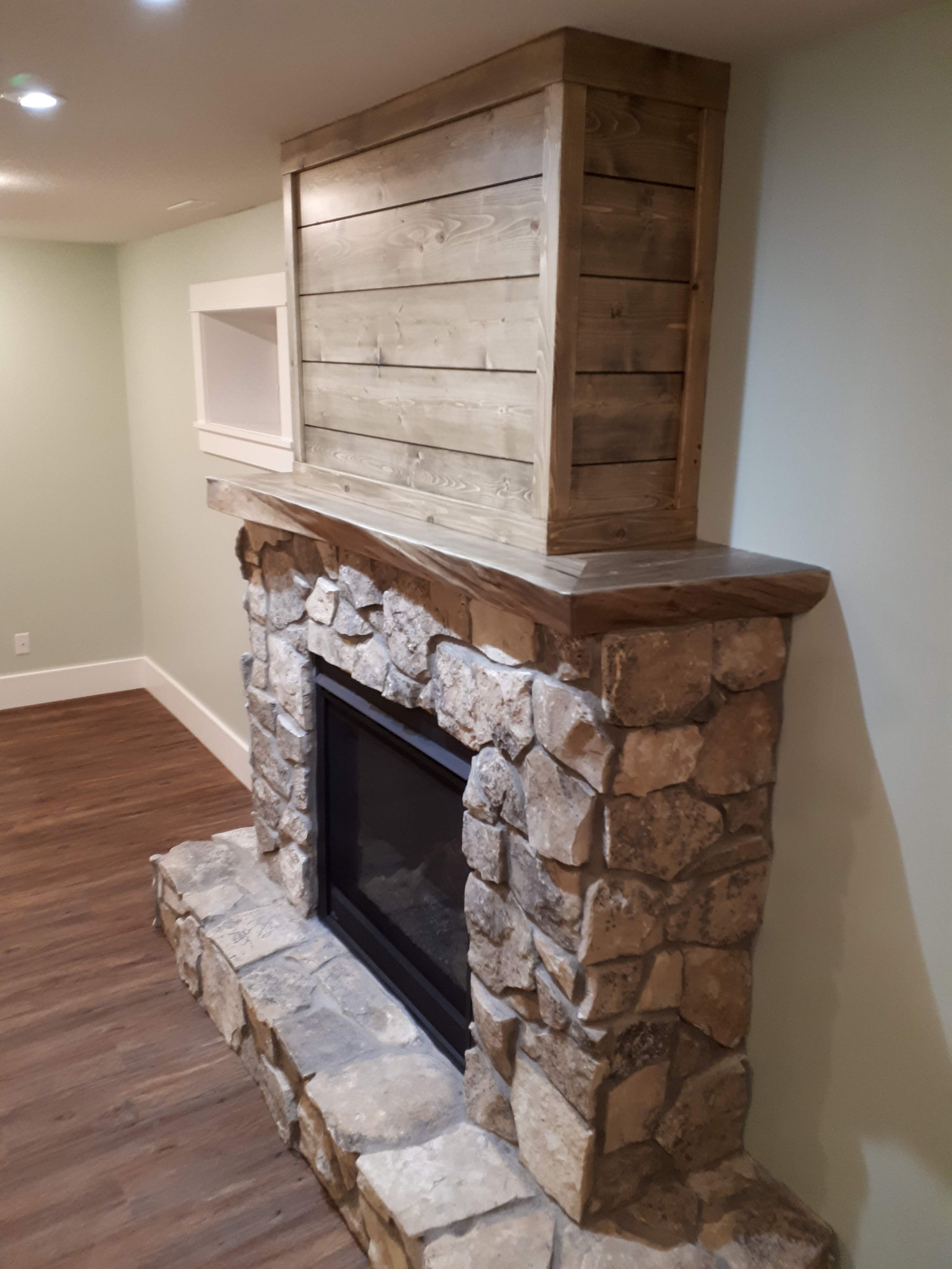fireplace with live edge slab mantle and ship lap above with stone below