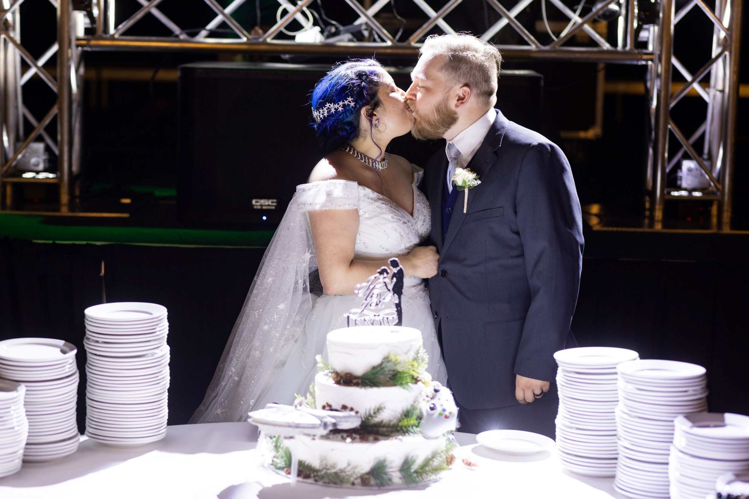 bride and groom kissing at cake.jpg