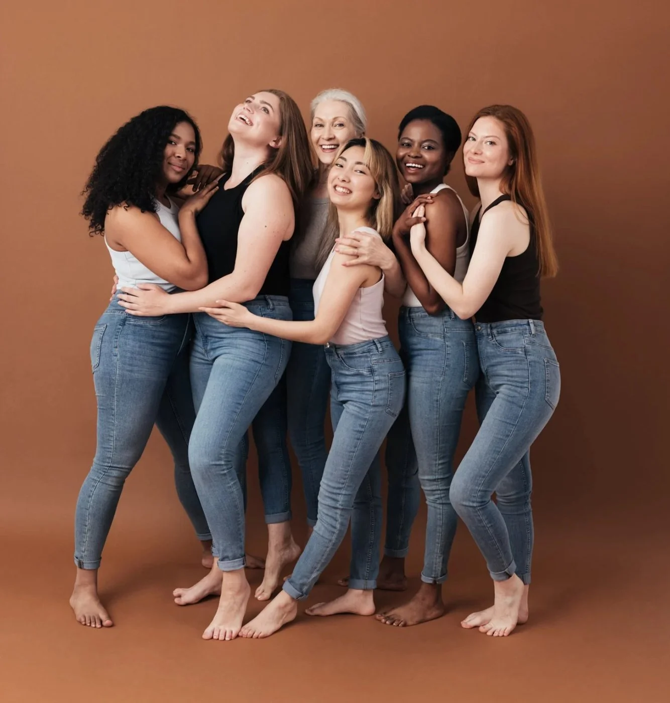 Six smiling women of different ages and backgrounds standing close together, embracing