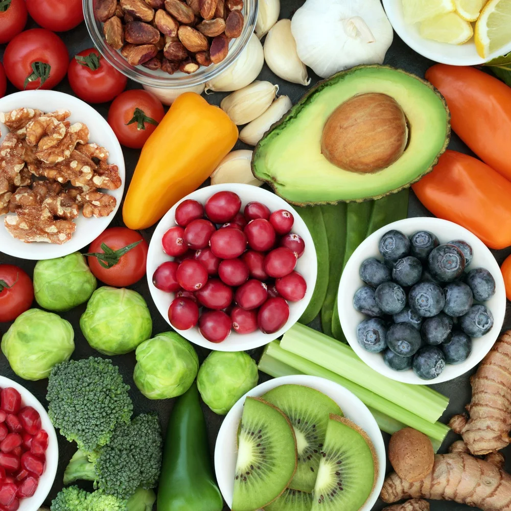 Colorful whole foods: berries, avocado, nuts, vegetables and fruit