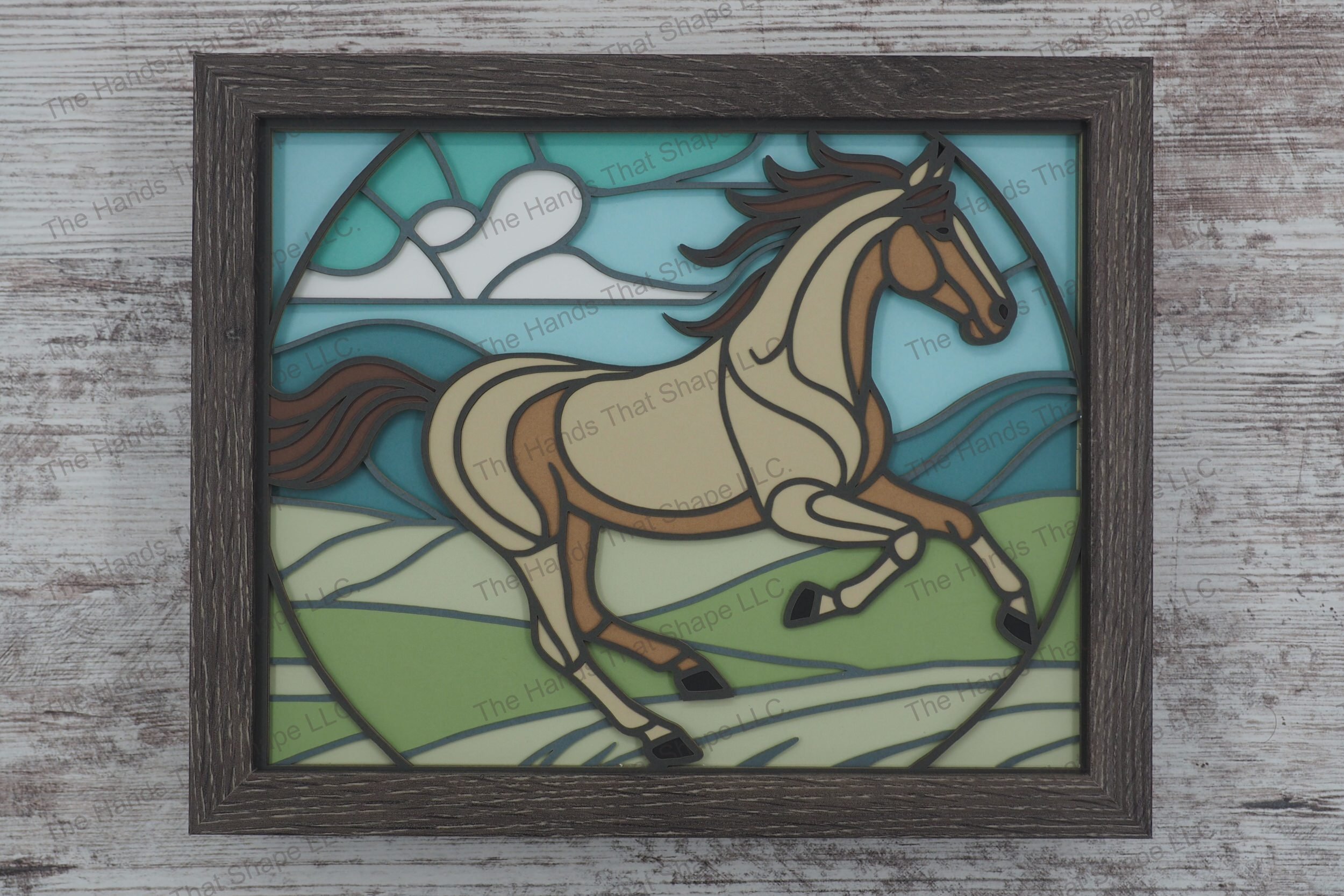 Experience the dynamic beauty of a horse in motion with this framed layered paper shadowbox art, featuring a horse galloping through hilly grasslands.