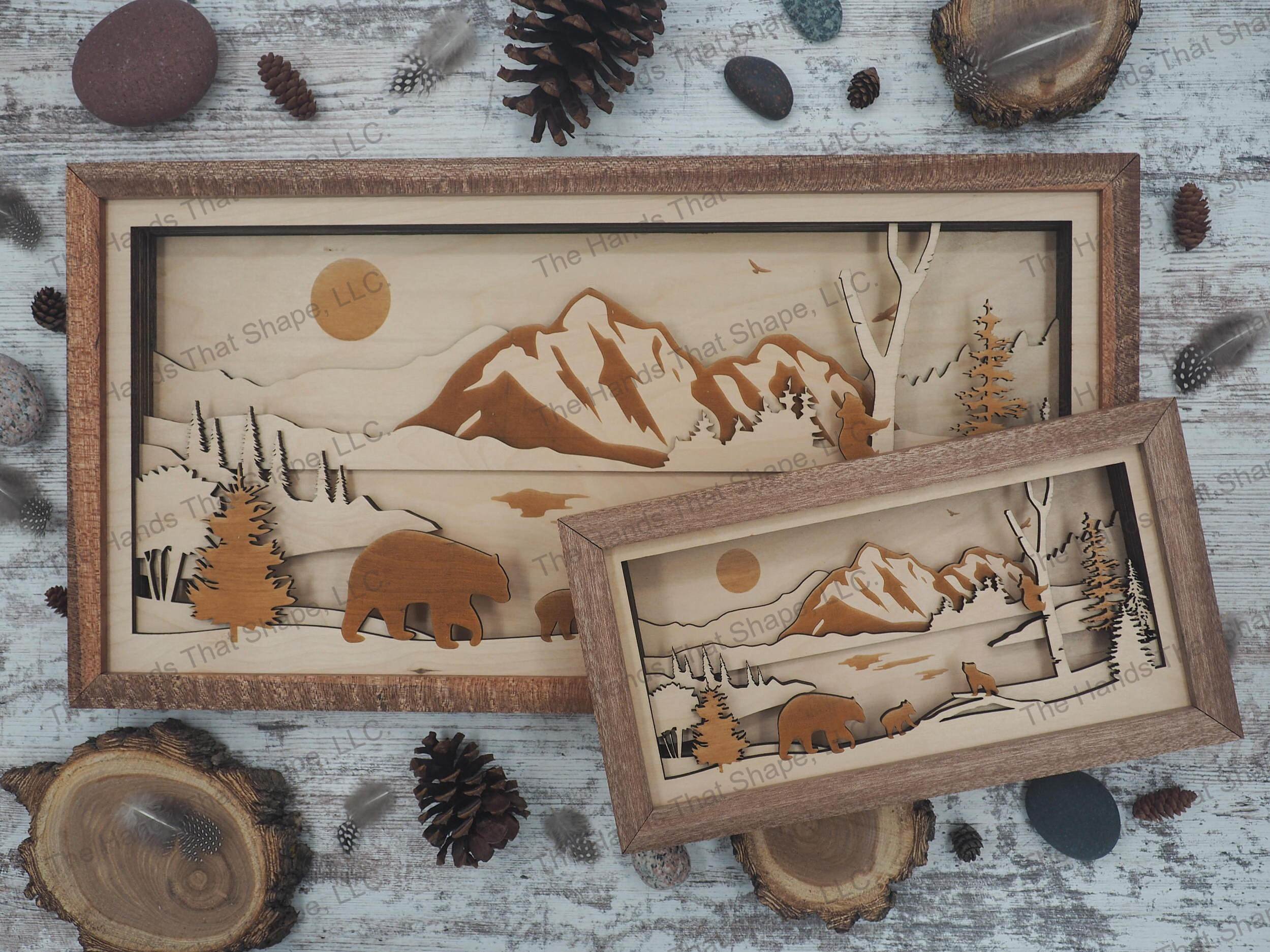 mama bear and cubs playing around a river with a majestic mountain range and eagle towering above