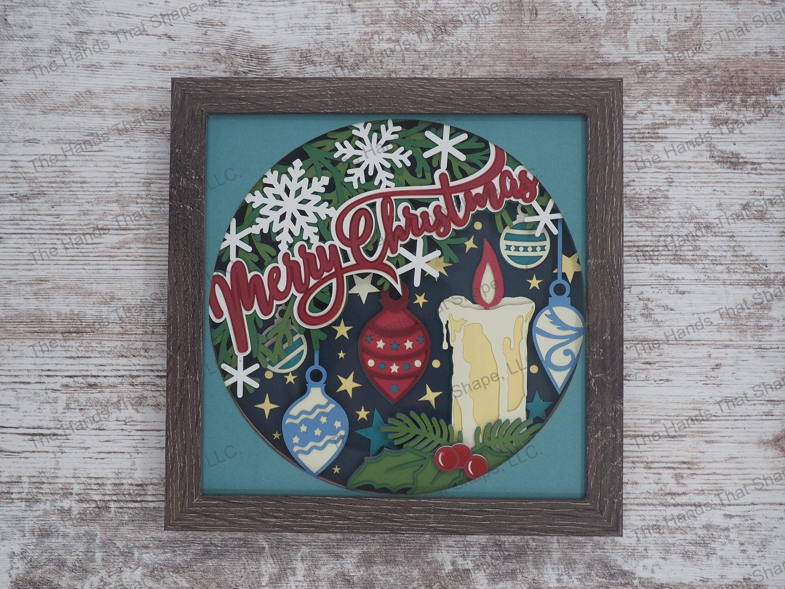 The shadow box features Christmas tree in the background full of ornaments, holly, berries, snowflakes and a Christmas Candle burning brightly with the words "Merry Christmas" dancing across the tree.
