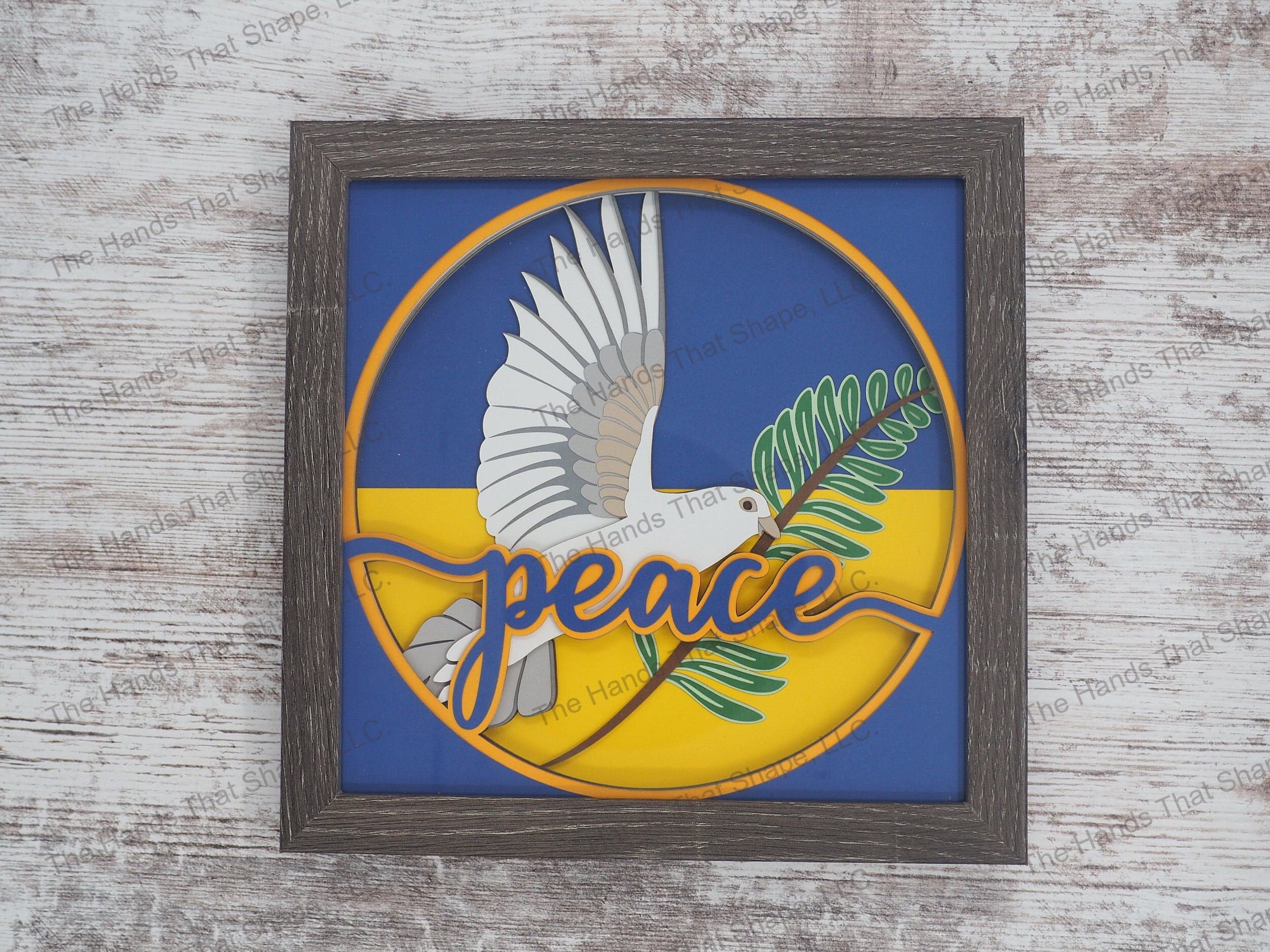 The “Peace” shadow box features a dove holding an olive branch as a reminder to add more tranquility to our lives. This one is made with Ukrainian flag colors.