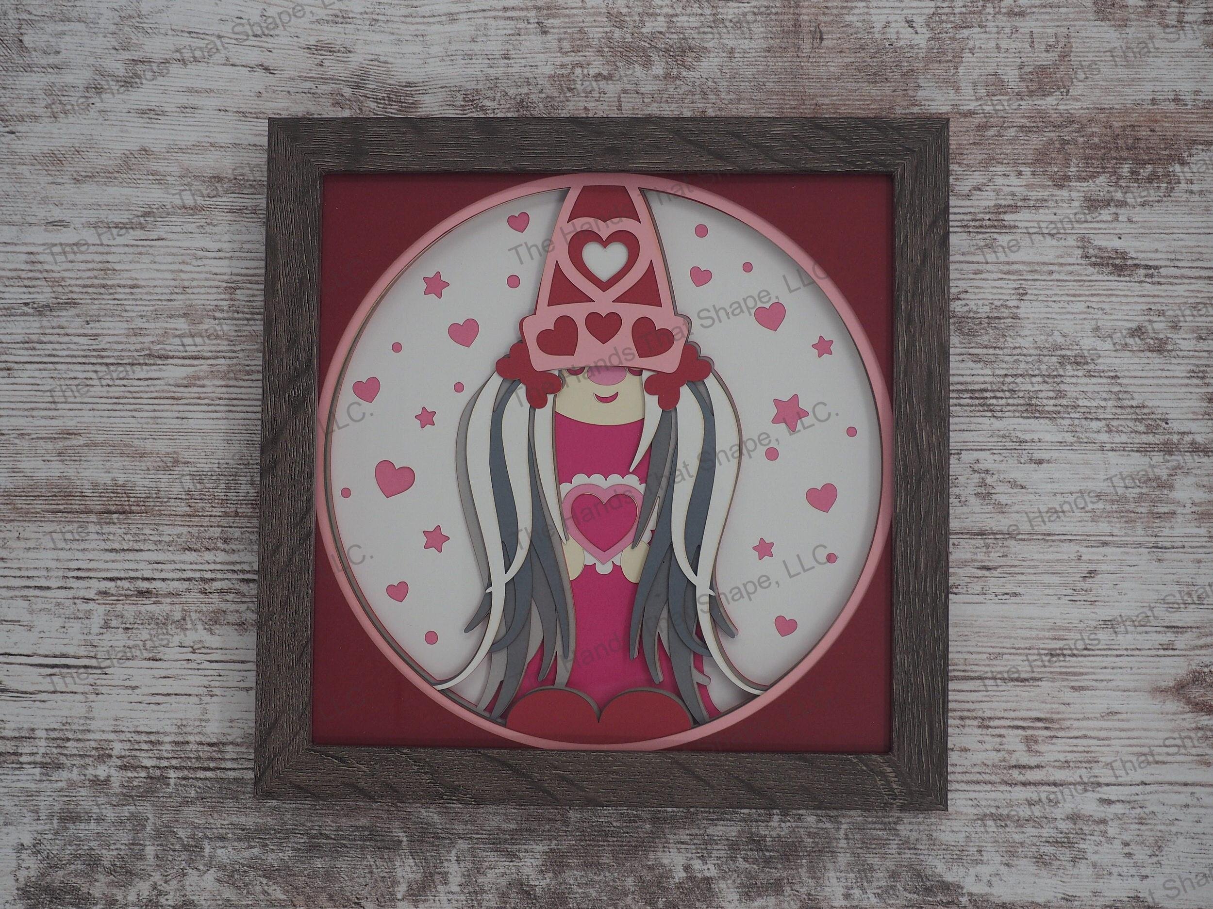 The ”Valentine Gnome” shadow box features a gnome covered in hearts and an abundance of reds and pinks, the colors of love.