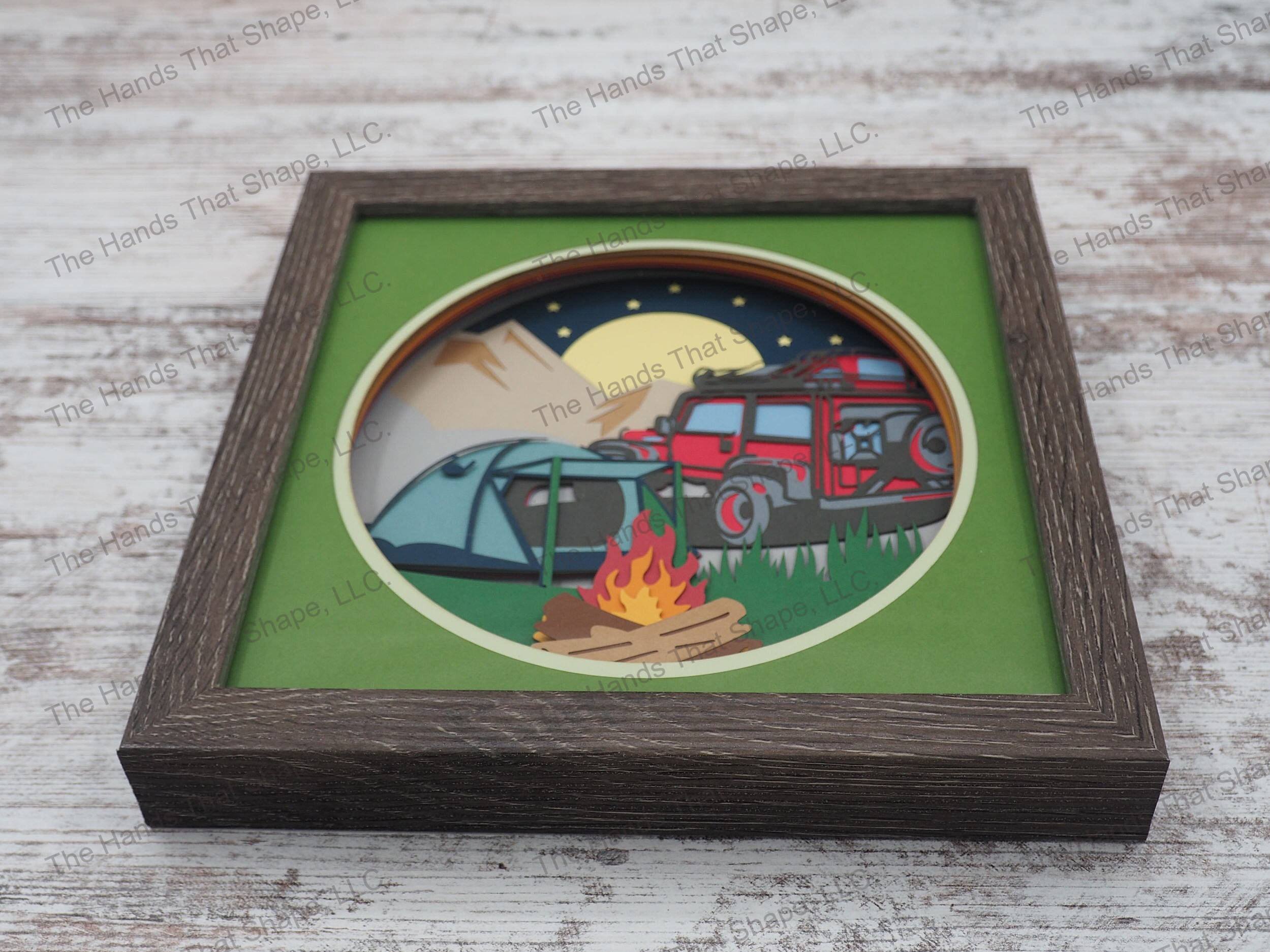 The shadow box features a tent and campfire with the off-roading vehicle parked in the background, ready to discover adventure around the next bend.