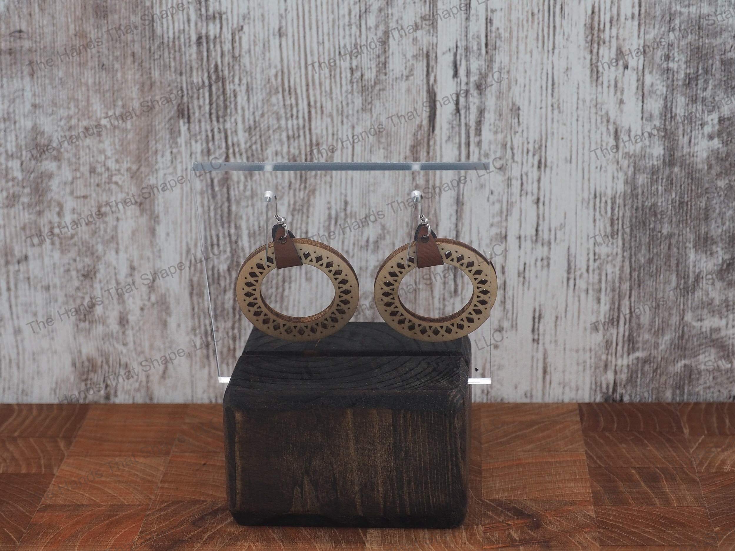 The Round Filagree earring features a dainty filagree cutout from a brown wooden hoop.