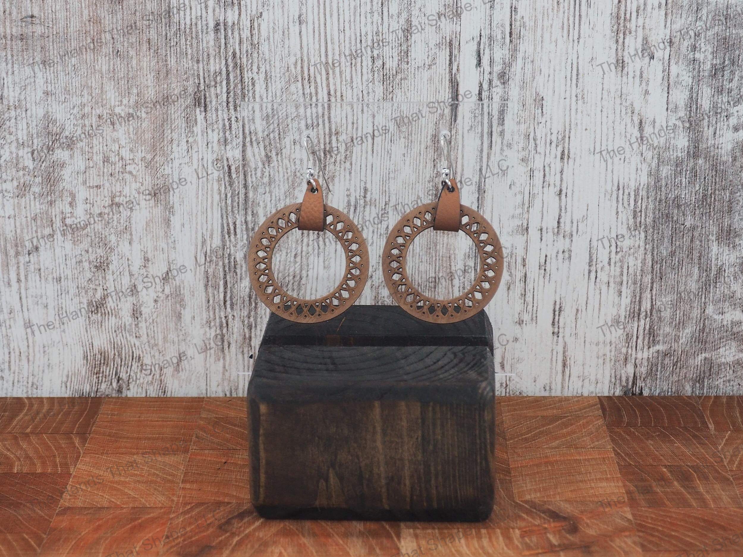 The Round Filagree earring features a dainty filagree cutout from a brown wooden hoop.