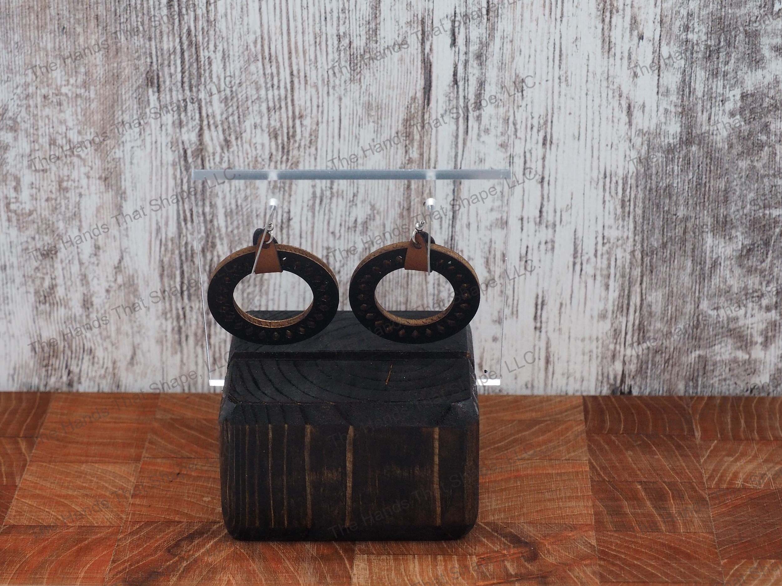 The Round Filagree earring features a dainty filagree cutout from a black wooden hoop.