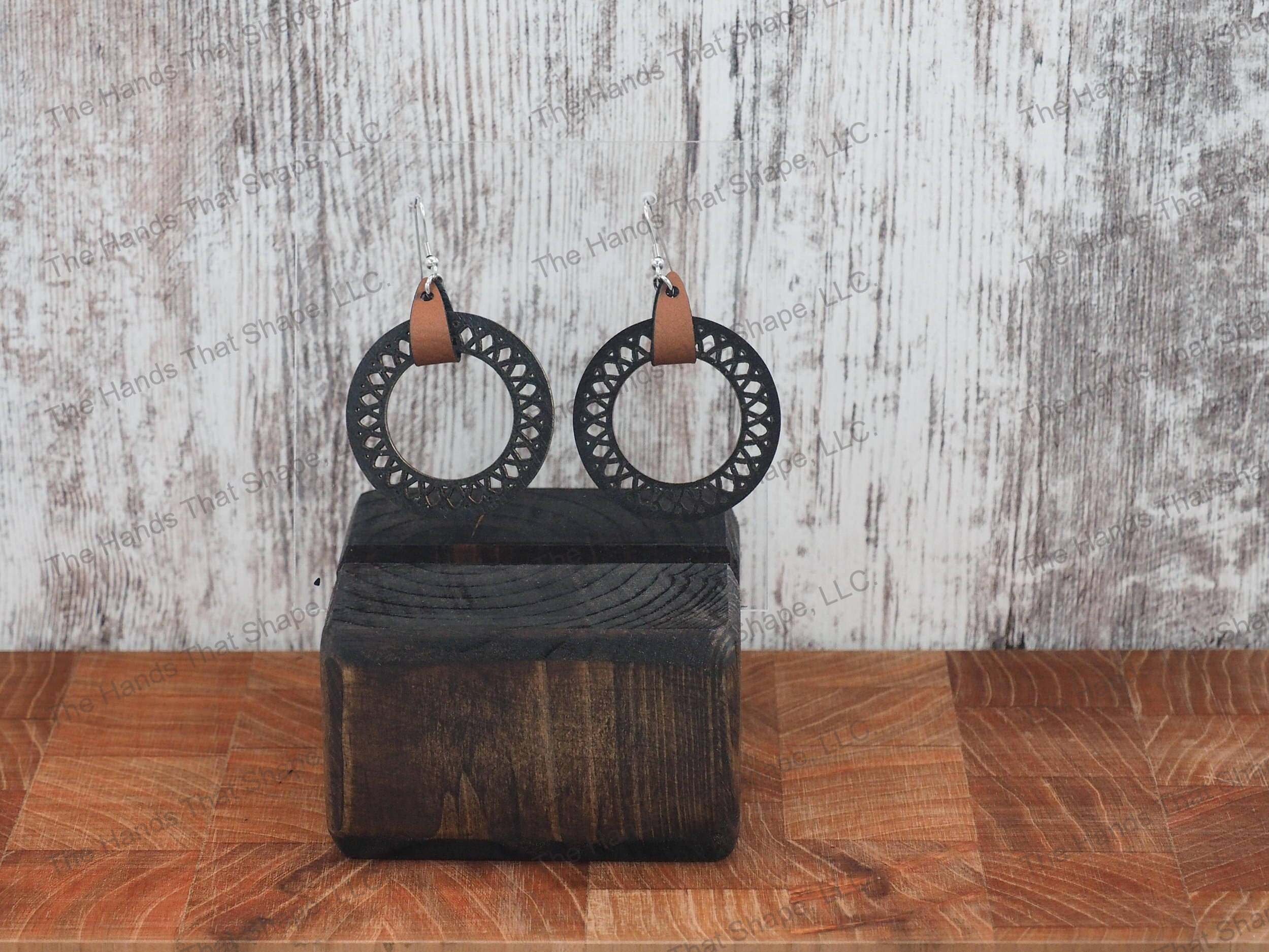 The Round Filagree earring features a dainty filagree cutout from a black wooden hoop.