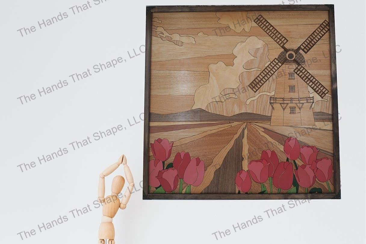 Finished windmill tulip field wood wall art piece staged on a living room, entranceway or dining room wall above a table with other art pieces.