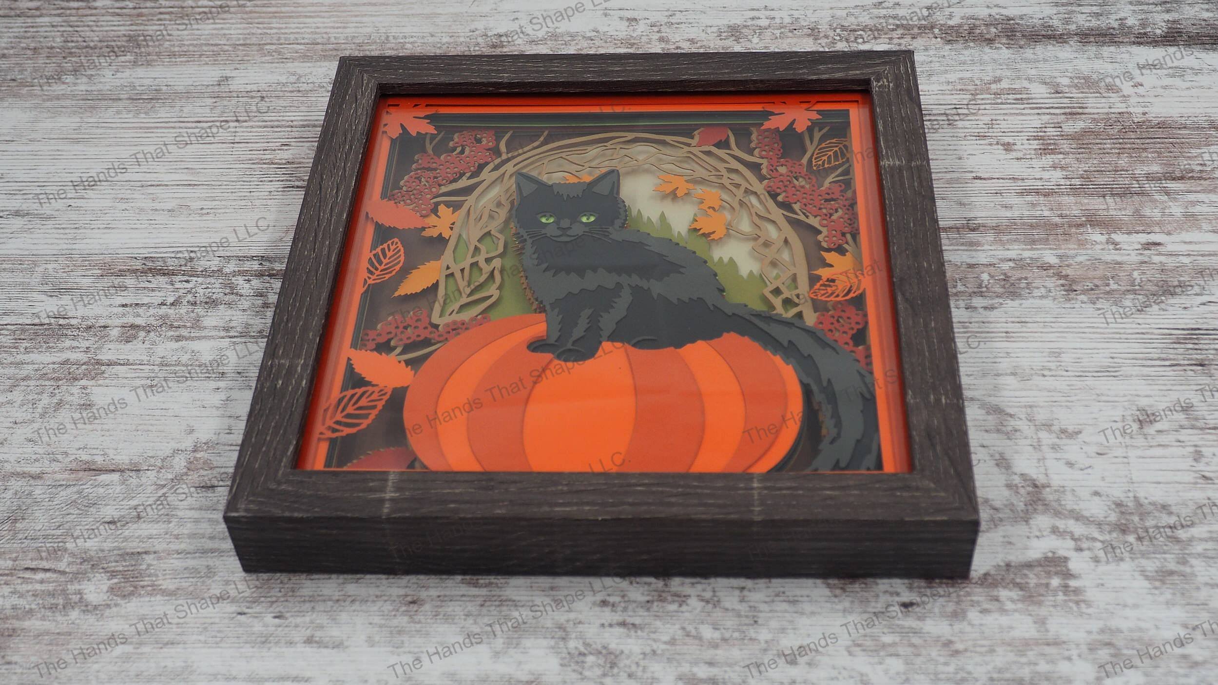 Autumn-themed 'Fall Cat on Pumpkin' shadowbox with 12 cardstock layers, featuring a black cat, pumpkin, and falling leaves in a gray MDF frame.