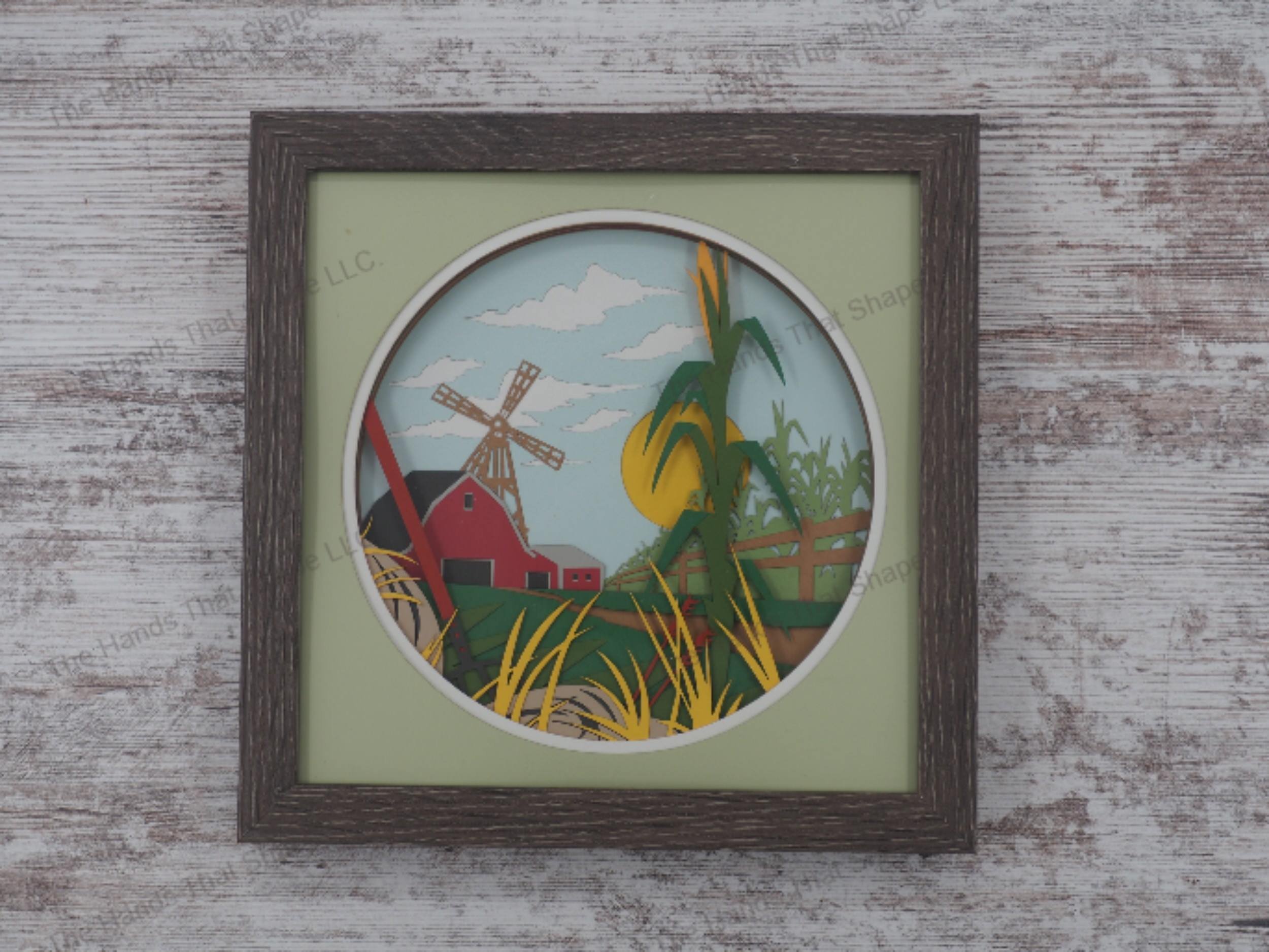 'Farm' layered paper shadowbox with a barn, windmill, cornfield, pitchfork, and sunny sky in 18-layer cardstock, framed in glass-covered gray MDF.
