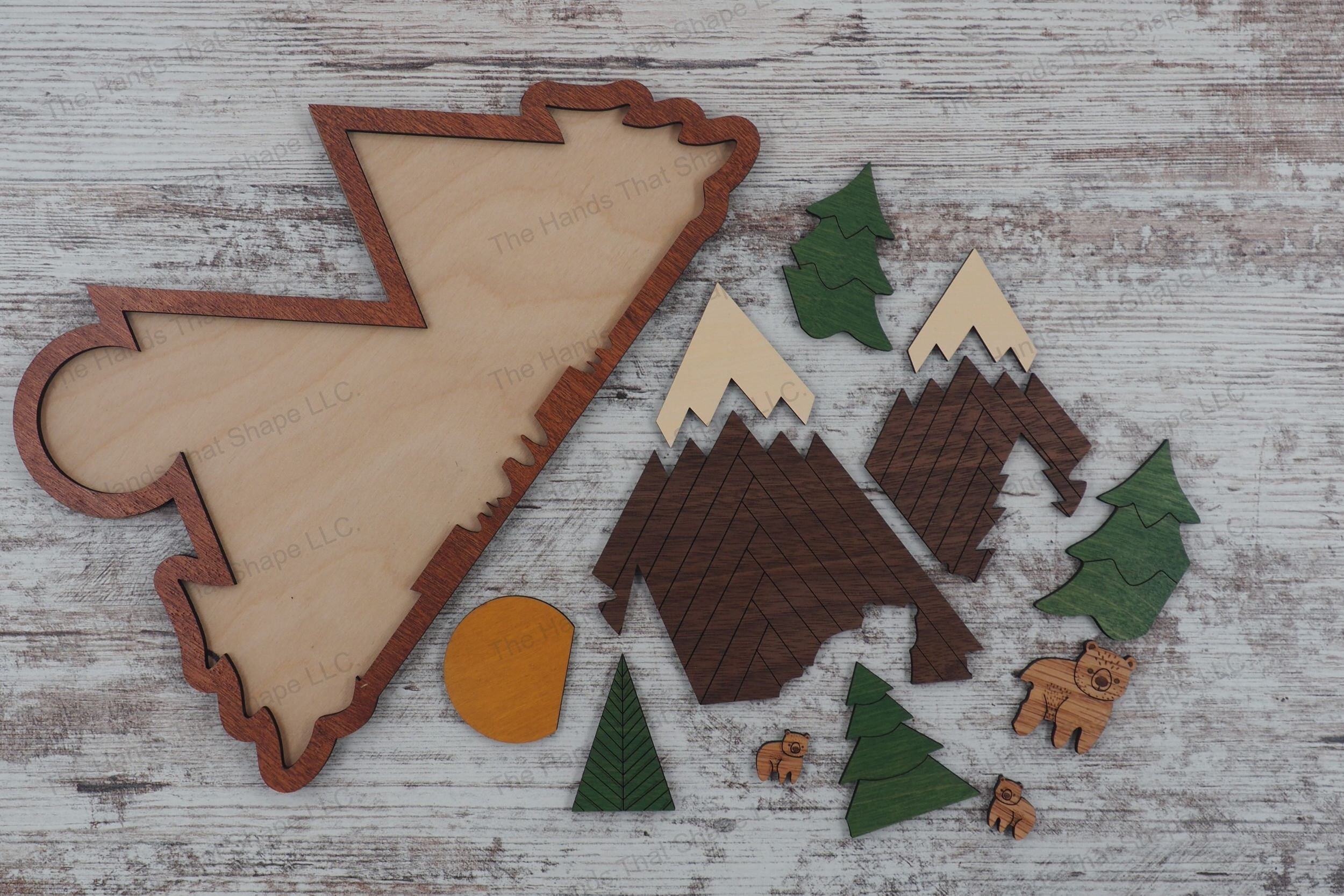 Craft serene 14 piece wood inlay nature scenes with our laser-ready design file featuring a bear family in a pine forest with mountains.