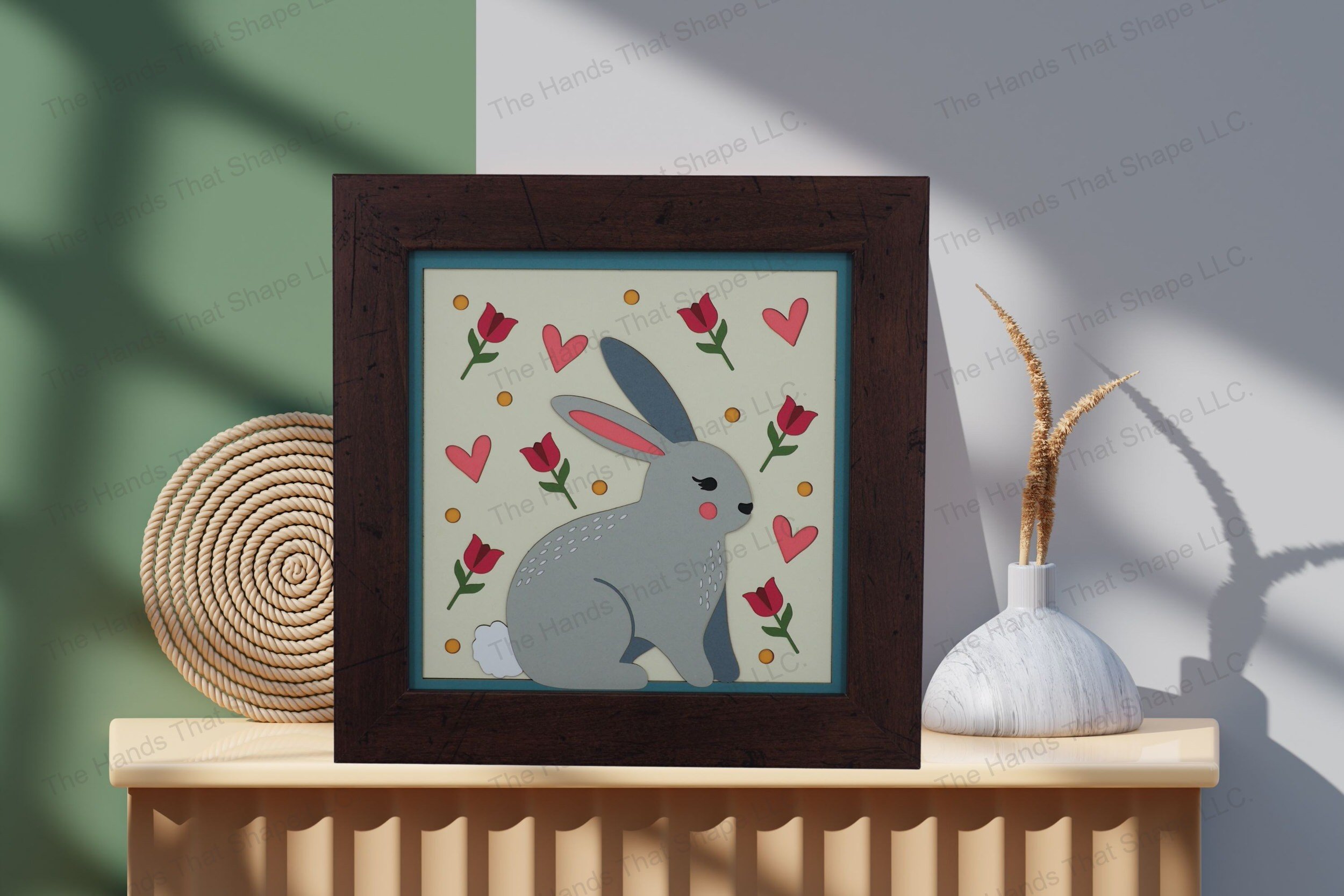 Admire this charming folksy bunny-themed cardstock artwork, thoughtfully displayed on a table, showcasing its vibrant layers and heartwarming pastoral details.