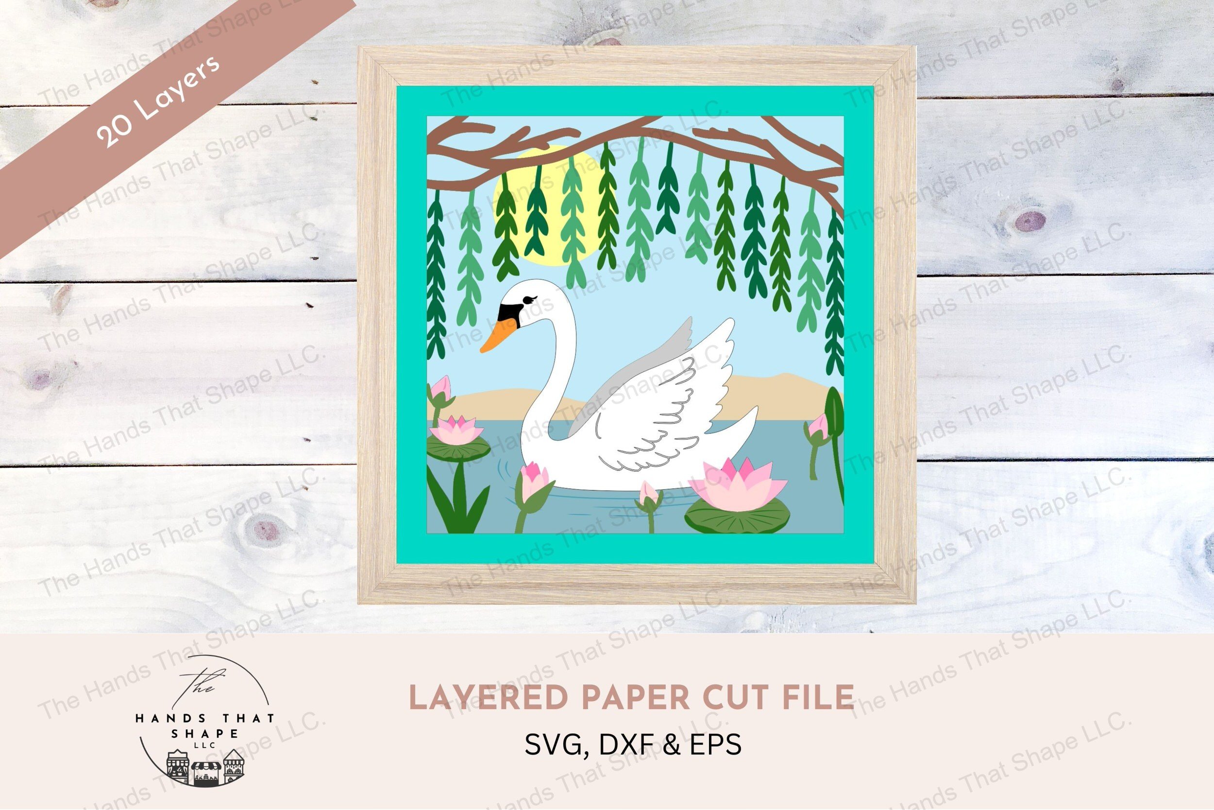 This layered cardstock art piece portrays a serene swan gliding under willow branches on a lake, surrounded by lily pads, creating a peaceful visual escape.