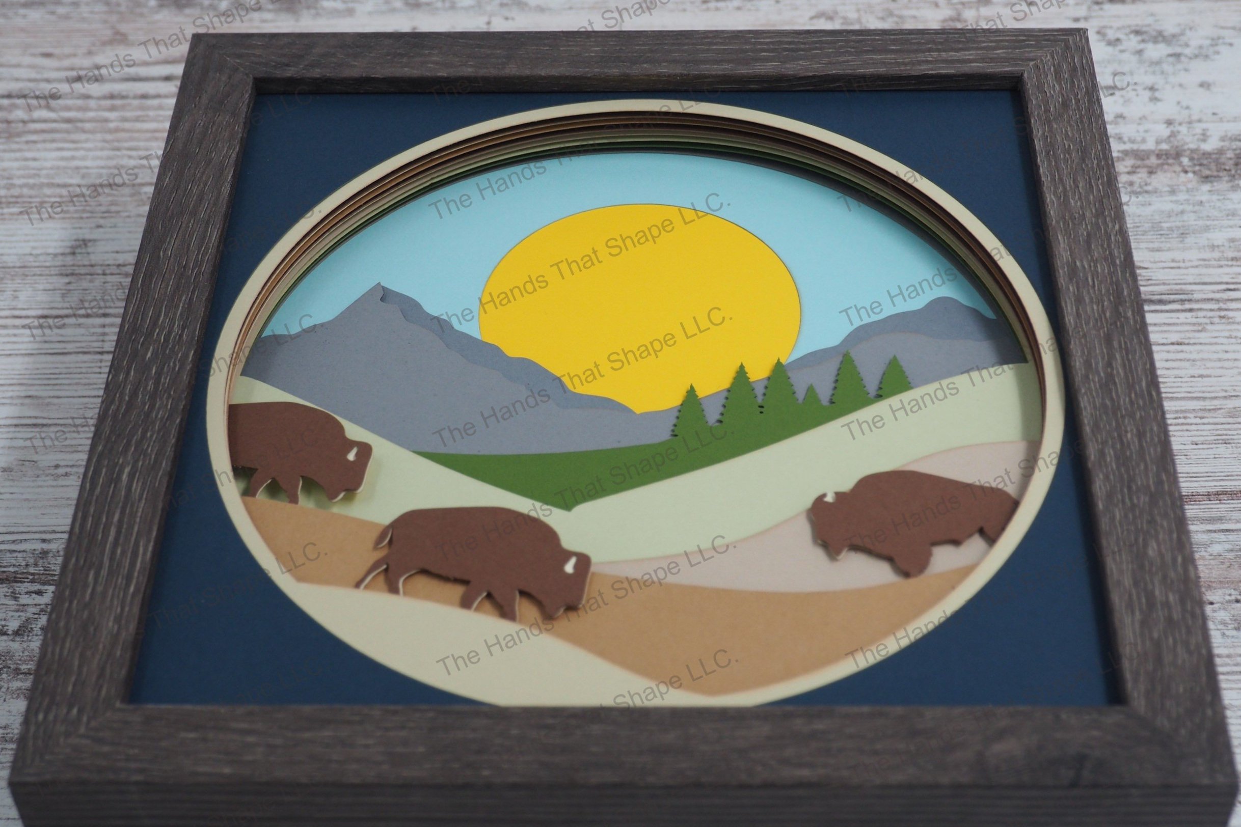 Capture the tranquil essence of the American prairie with this layered paper shadowbox, featuring bison grazing on rolling hills and distant mountains.