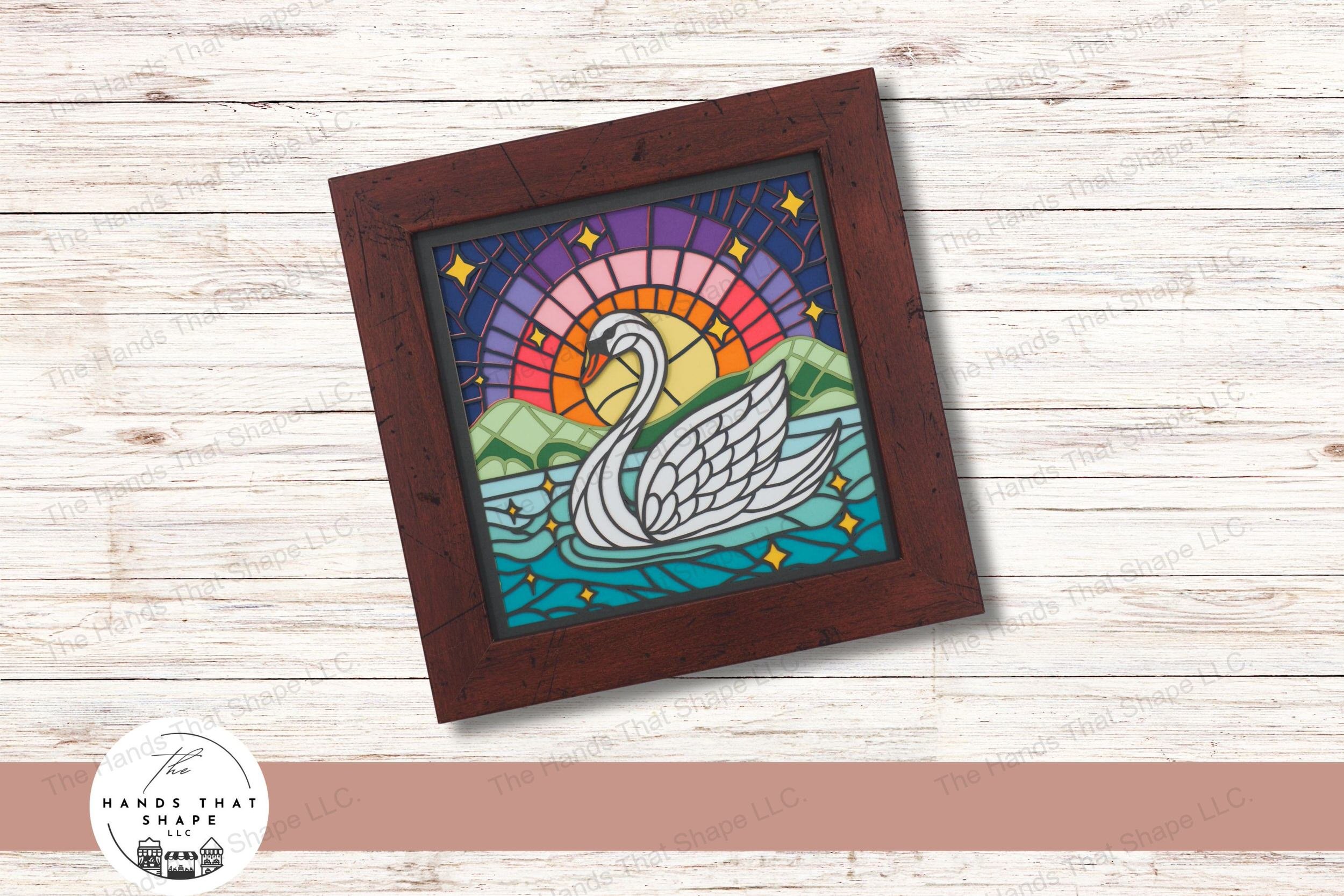 This exquisite layered cardstock art piece showcases a serene swan on a lake against a backdrop of a colorful sunrise, enhanced by twinkling stars.