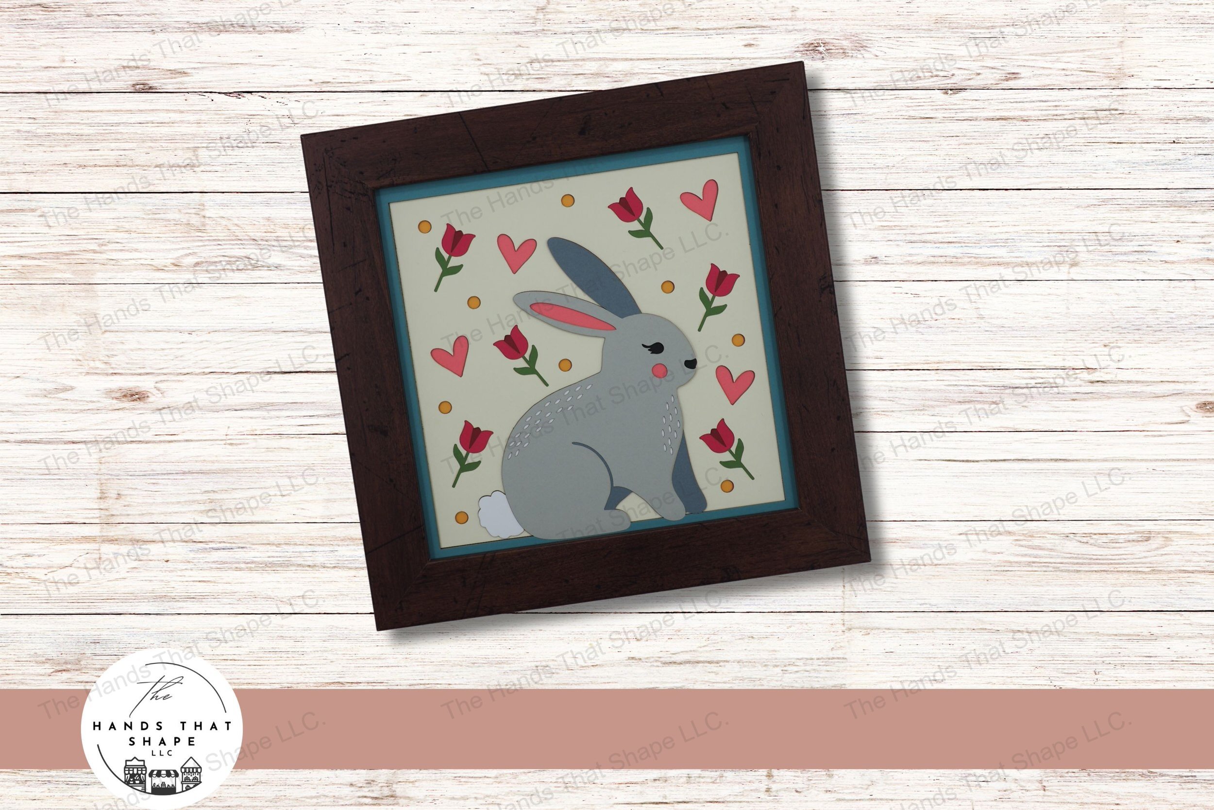This layered cardstock art piece beautifully captures a whimsical folksy bunny, surrounded by a colorful array of tulips, hearts, and decorative dots.