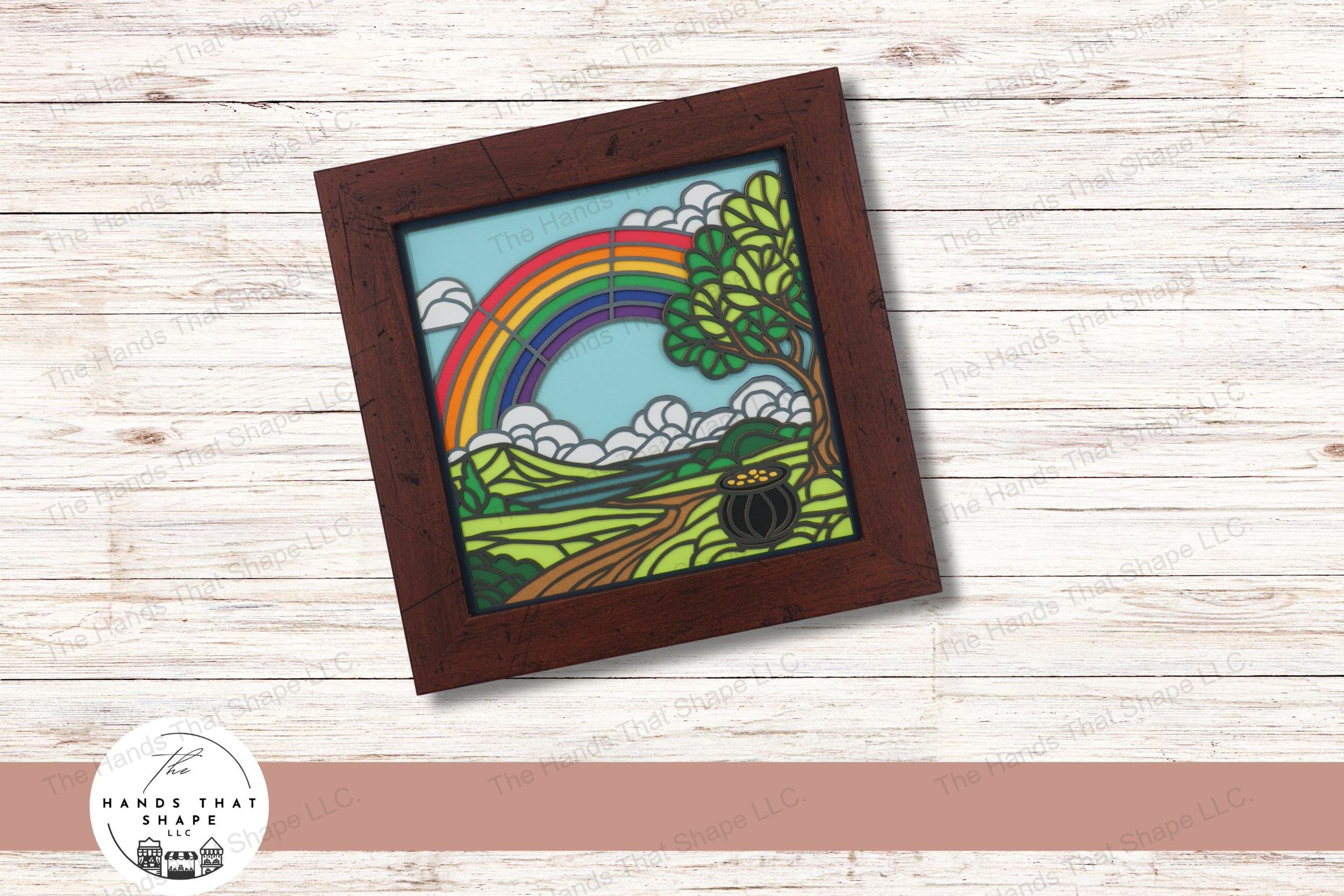 This layered cardstock art piece vividly captures a scenic pot of gold at the end of a rainbow, creating a charming and colorful display.
