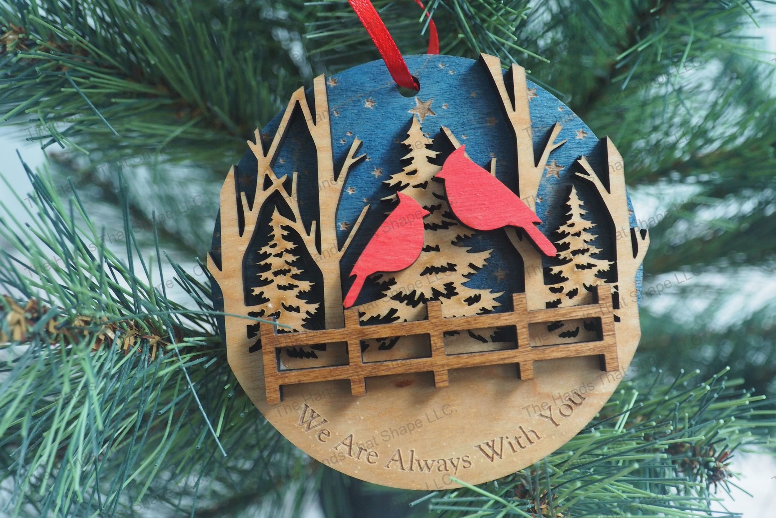 A Christmas tree adorned with our beautifully crafted wooden ornament, featuring two cardinals in a multi-layered design and a heartfelt engraving.