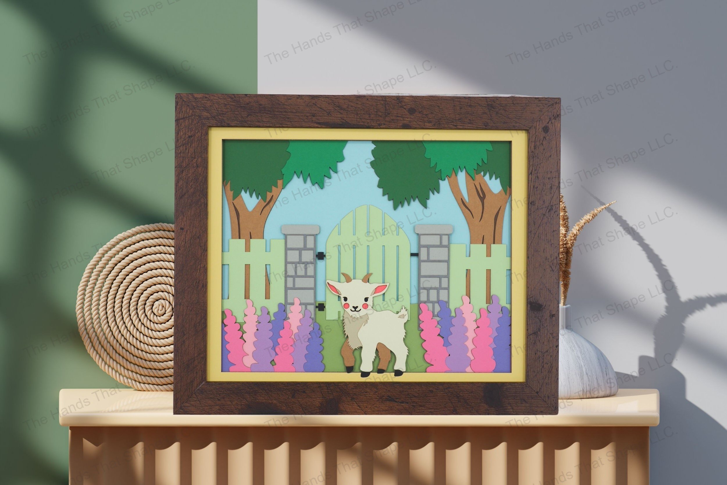 Admire this goat by a gate-themed cardstock artwork, displayed on a table, showcasing its rich layers and the enchanting detail of a serene pastoral setting.