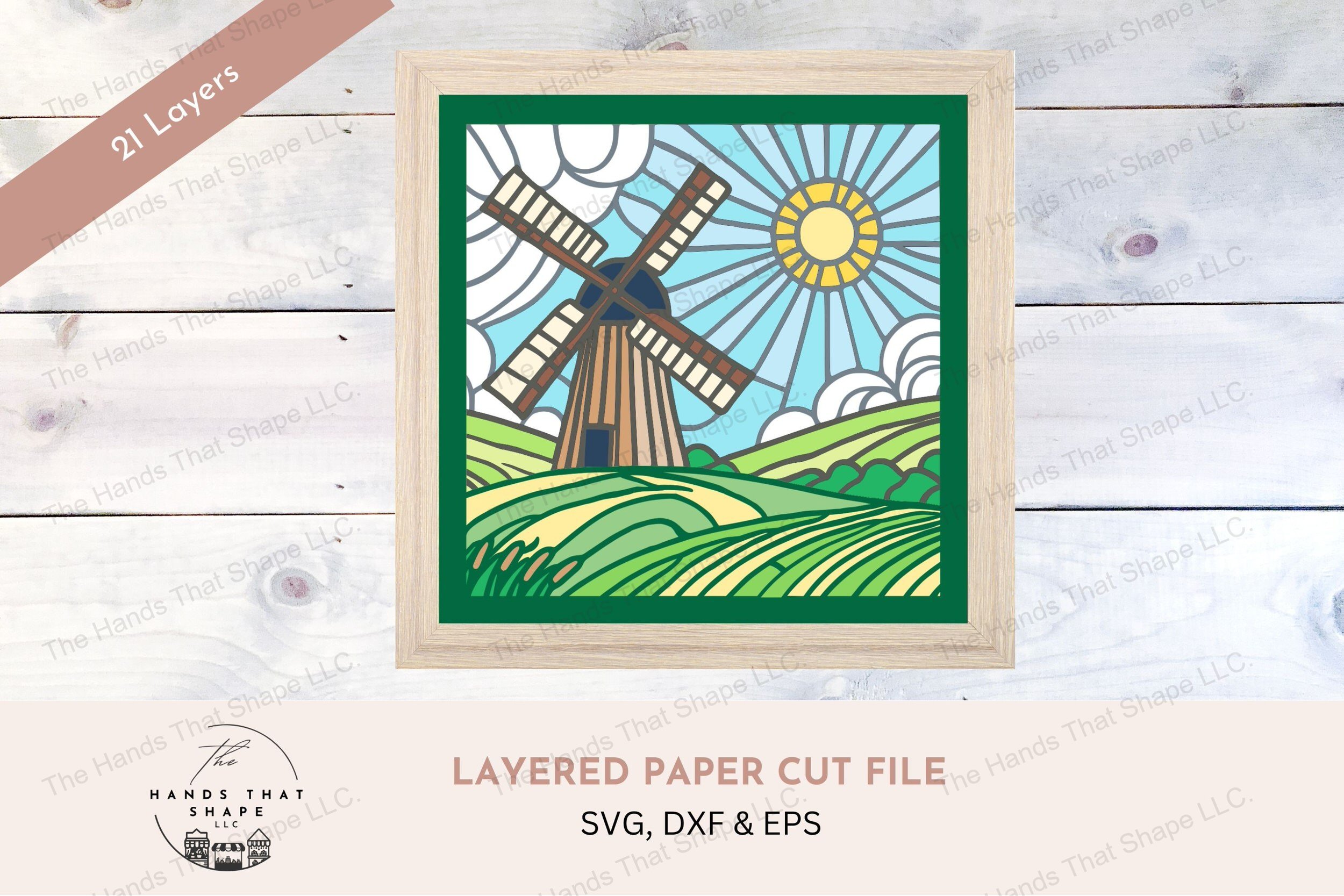 This layered cardstock art piece beautifully depicts an old windmill amidst rolling hills under a sunlit sky evoking the charm of the countryside.
