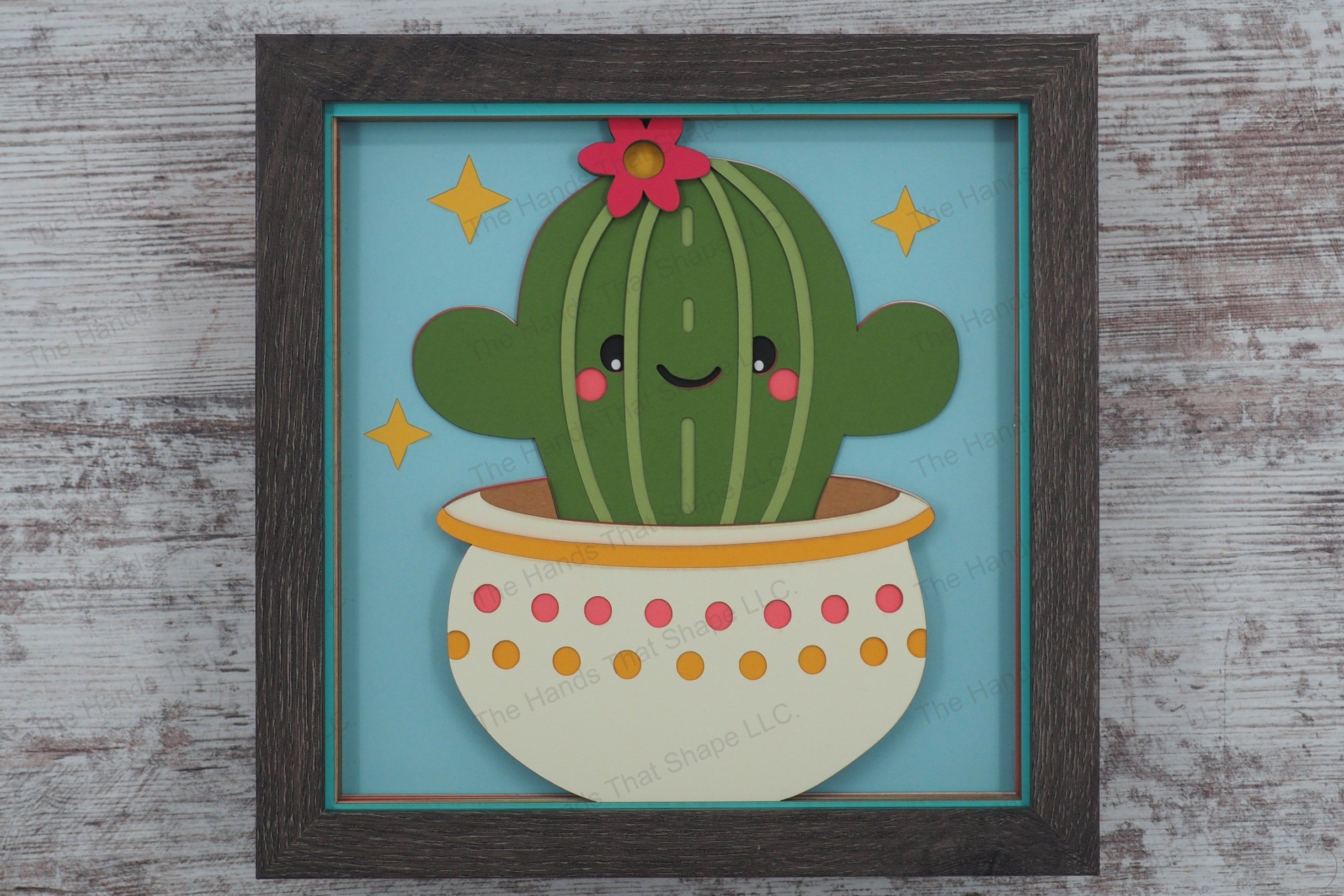 Delight in the whimsical charm of a smiling cactus with human-like features, crafted from layers of colored premium cardstock to create a vivid 3D effect.