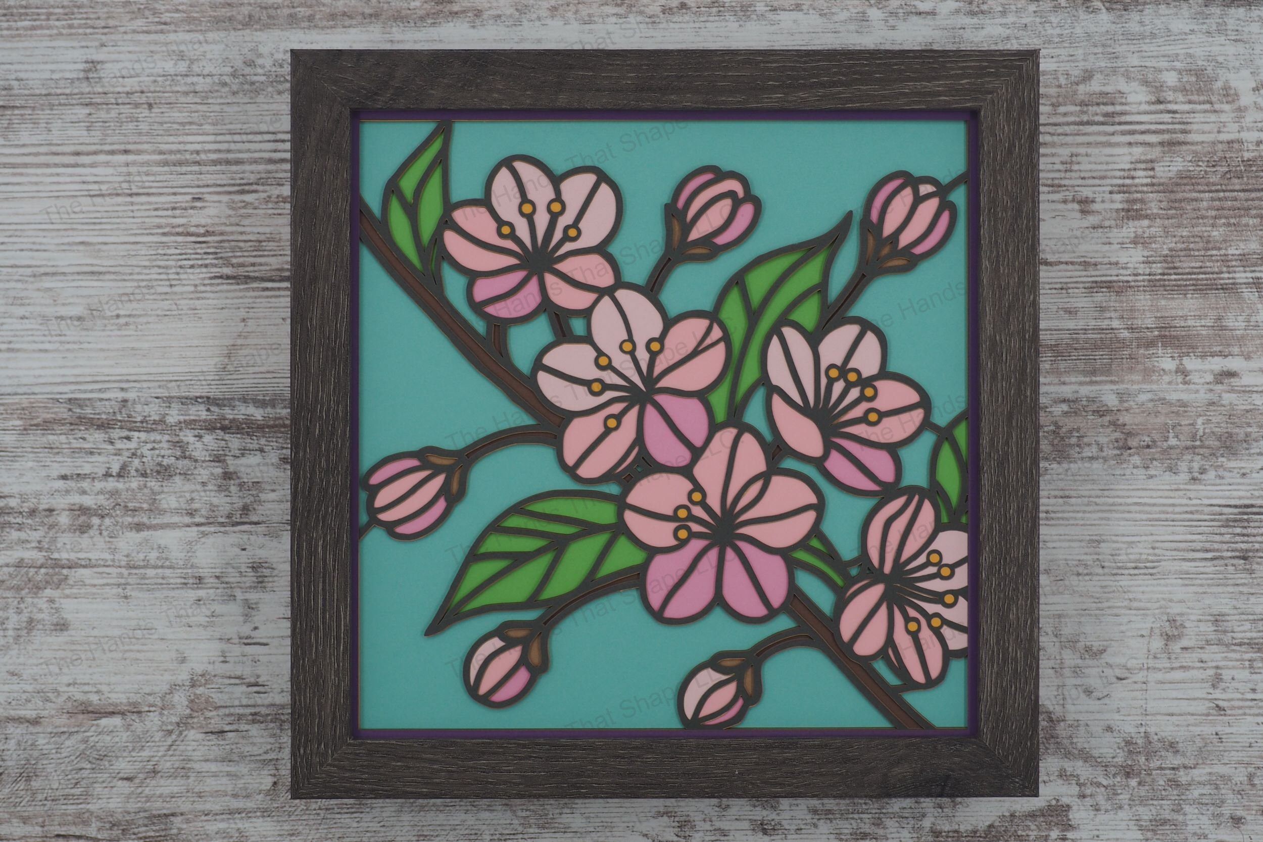 Experience the beauty of cherry blossoms through this intricately crafted shadowbox, featuring a branch in bloom styled in stained glass with colored cardstock.
